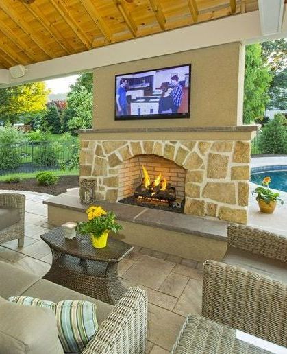 A living room with a fireplace and a television on the wall.