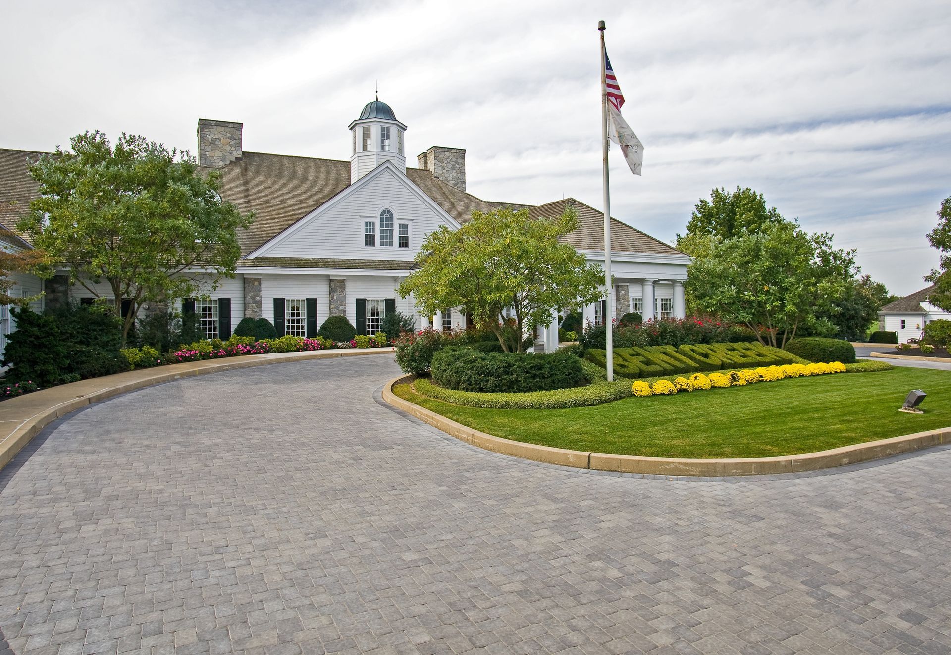 A large white house with a flag in front of it