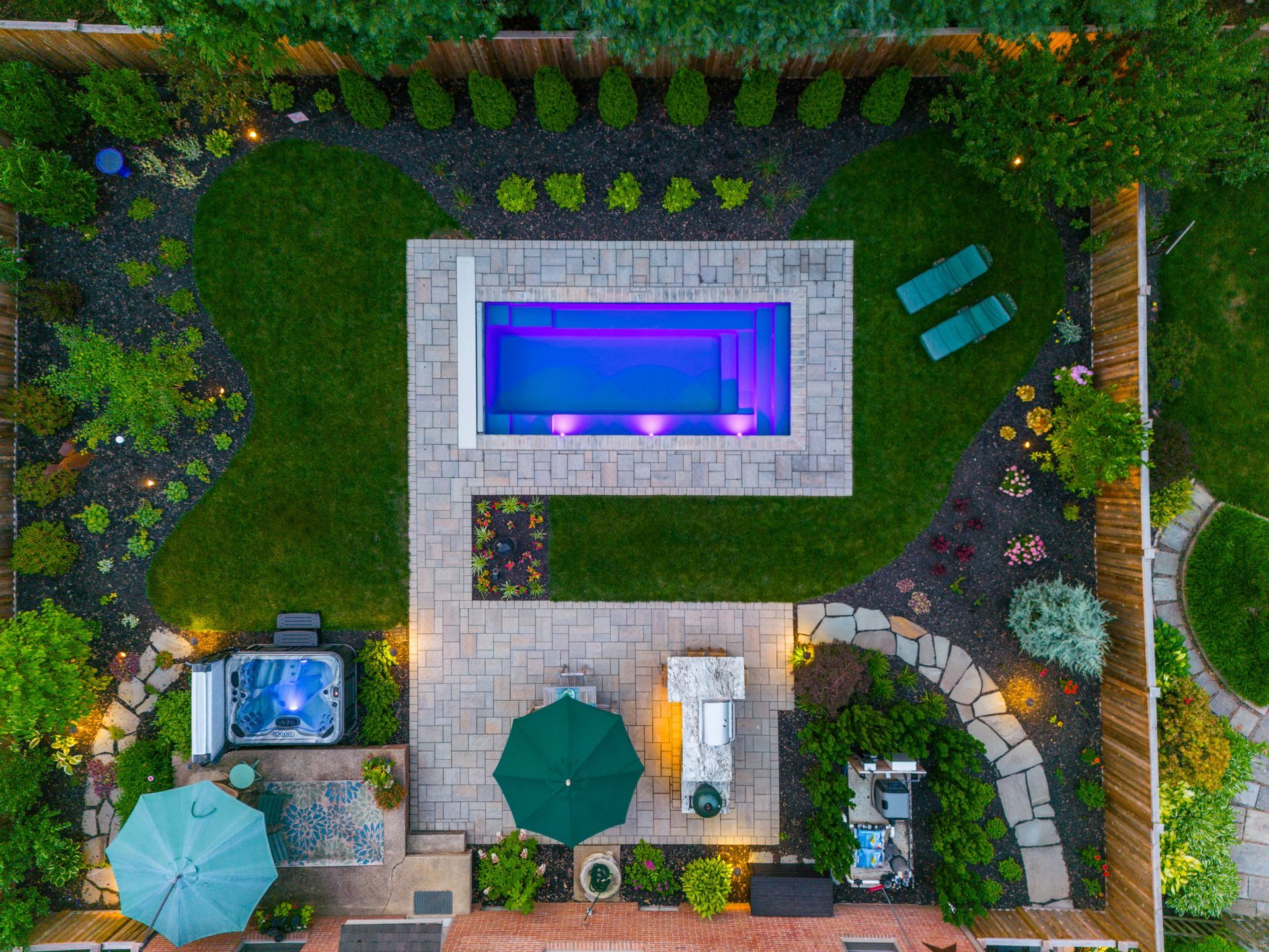 An aerial view of a backyard with a large swimming pool and a hot tub.