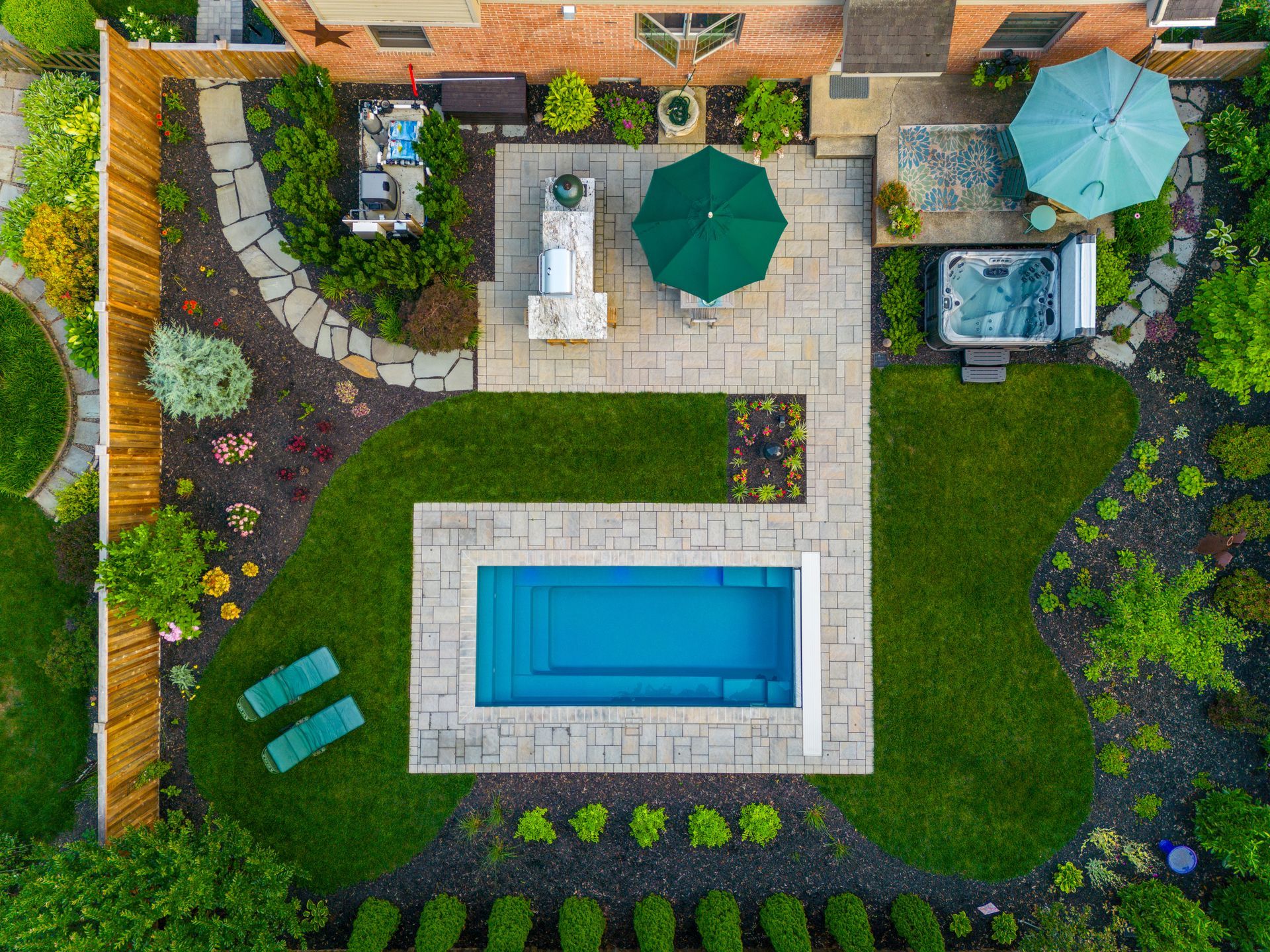 An aerial view of a backyard with a large swimming pool and a hot tub.