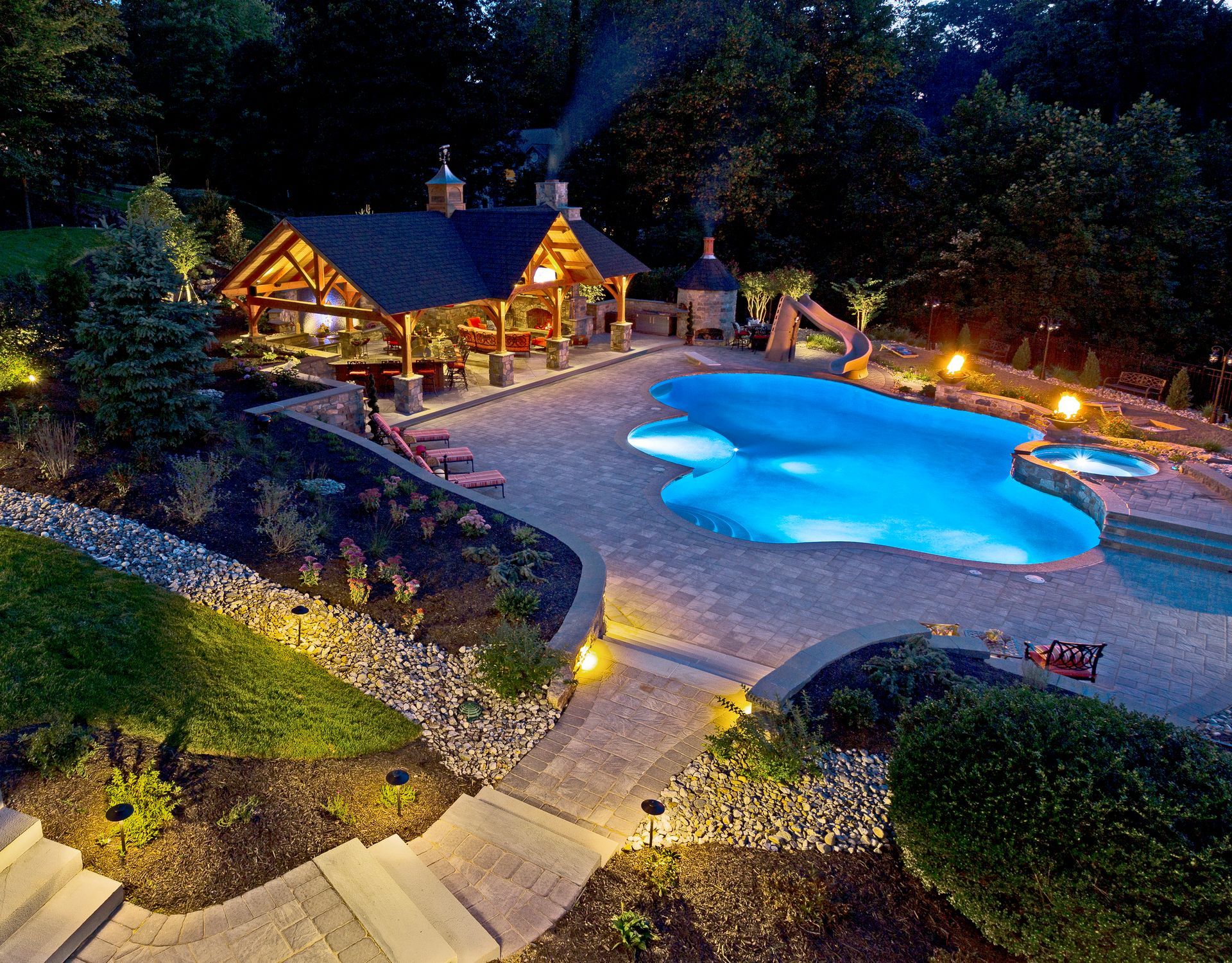 A large swimming pool is lit up at night