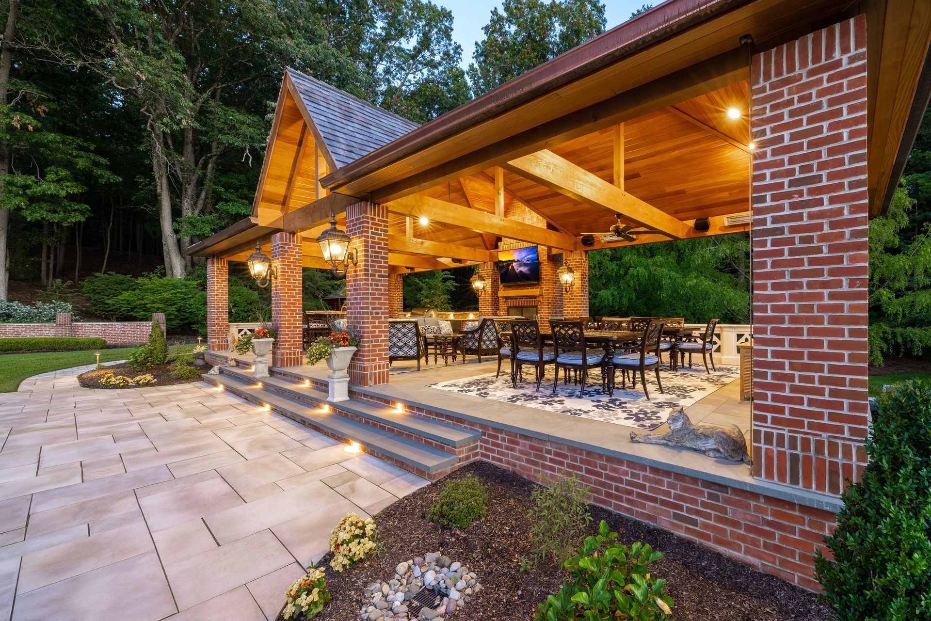A large covered patio with a wooden roof and brick pillars.