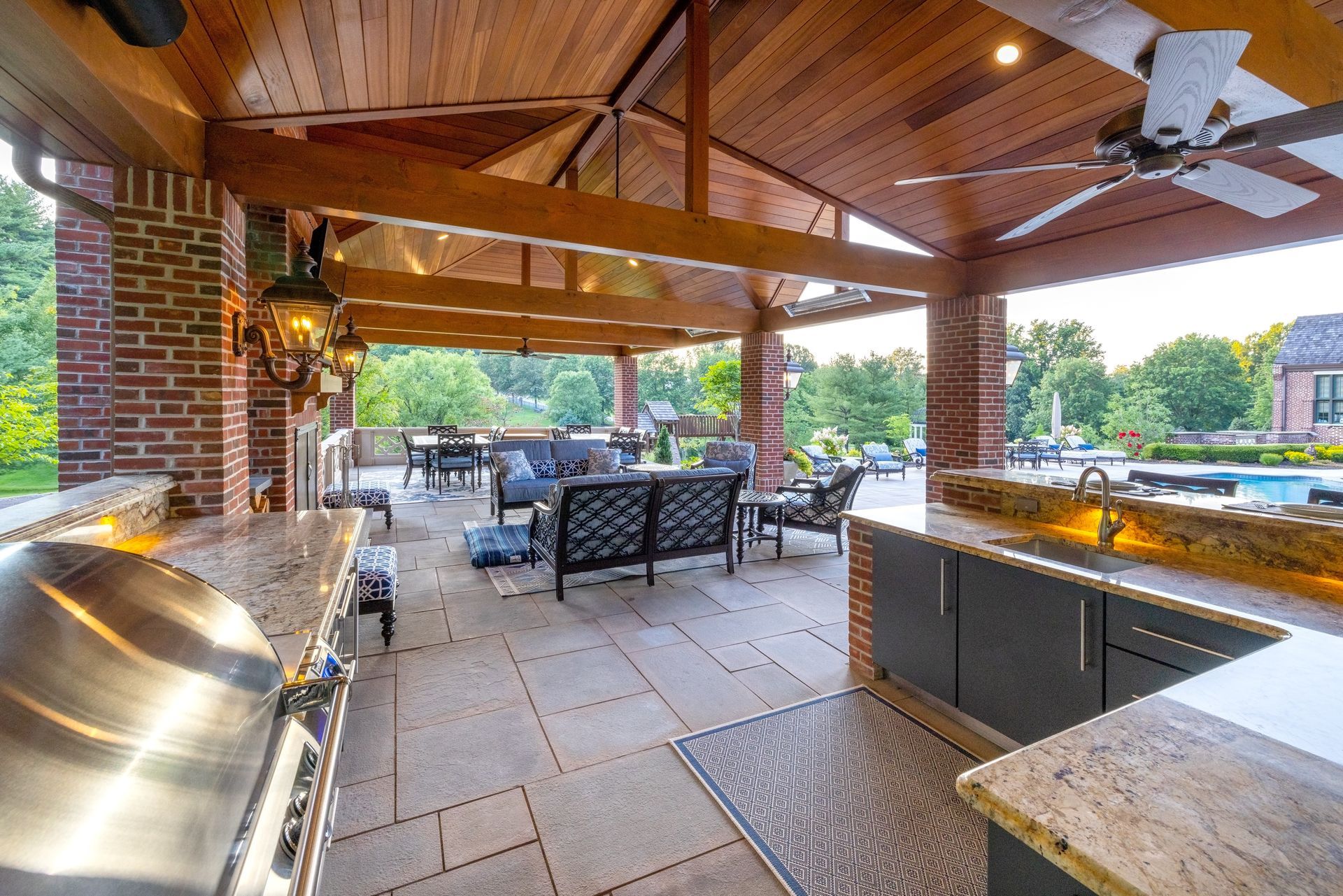 A large outdoor kitchen with a grill and a ceiling fan.