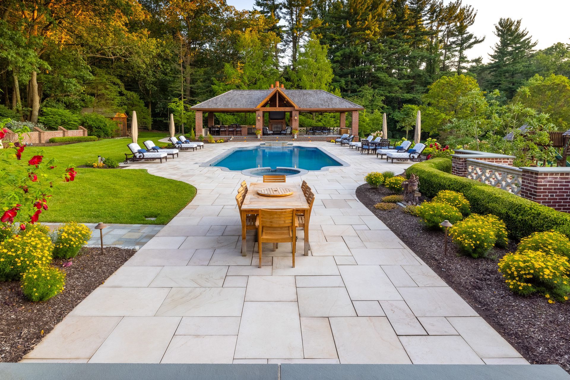 A patio with a table and chairs next to a large pool