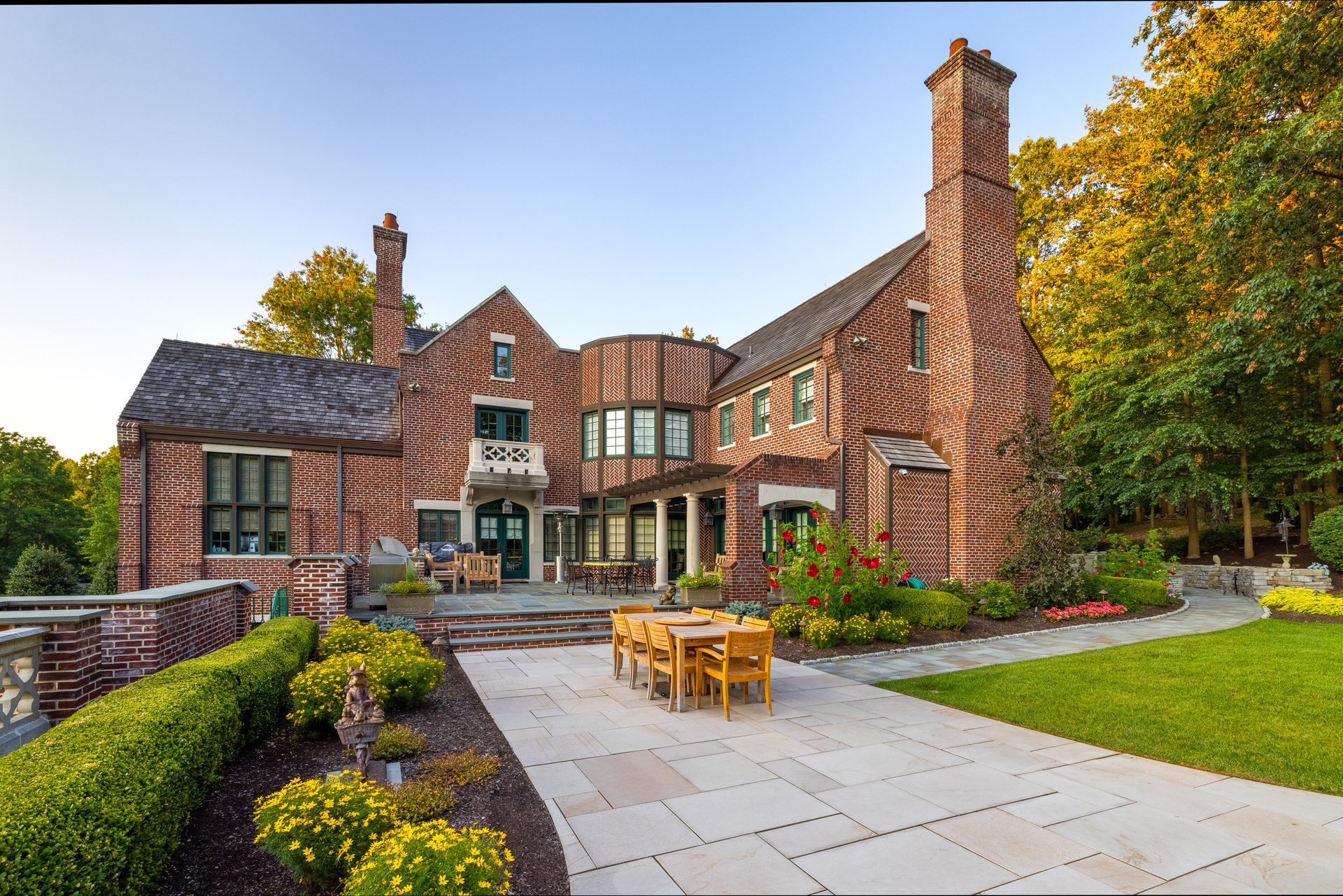 A large brick house with a patio in front of it
