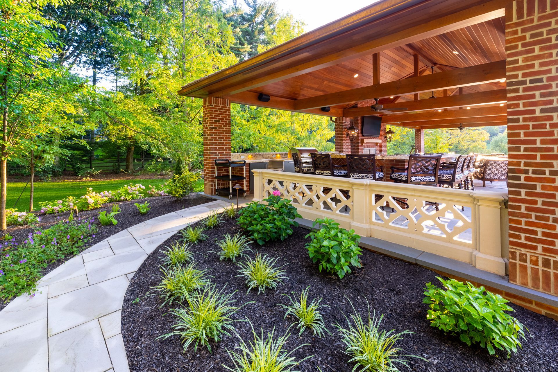 A brick house with a covered patio and a walkway leading to it.