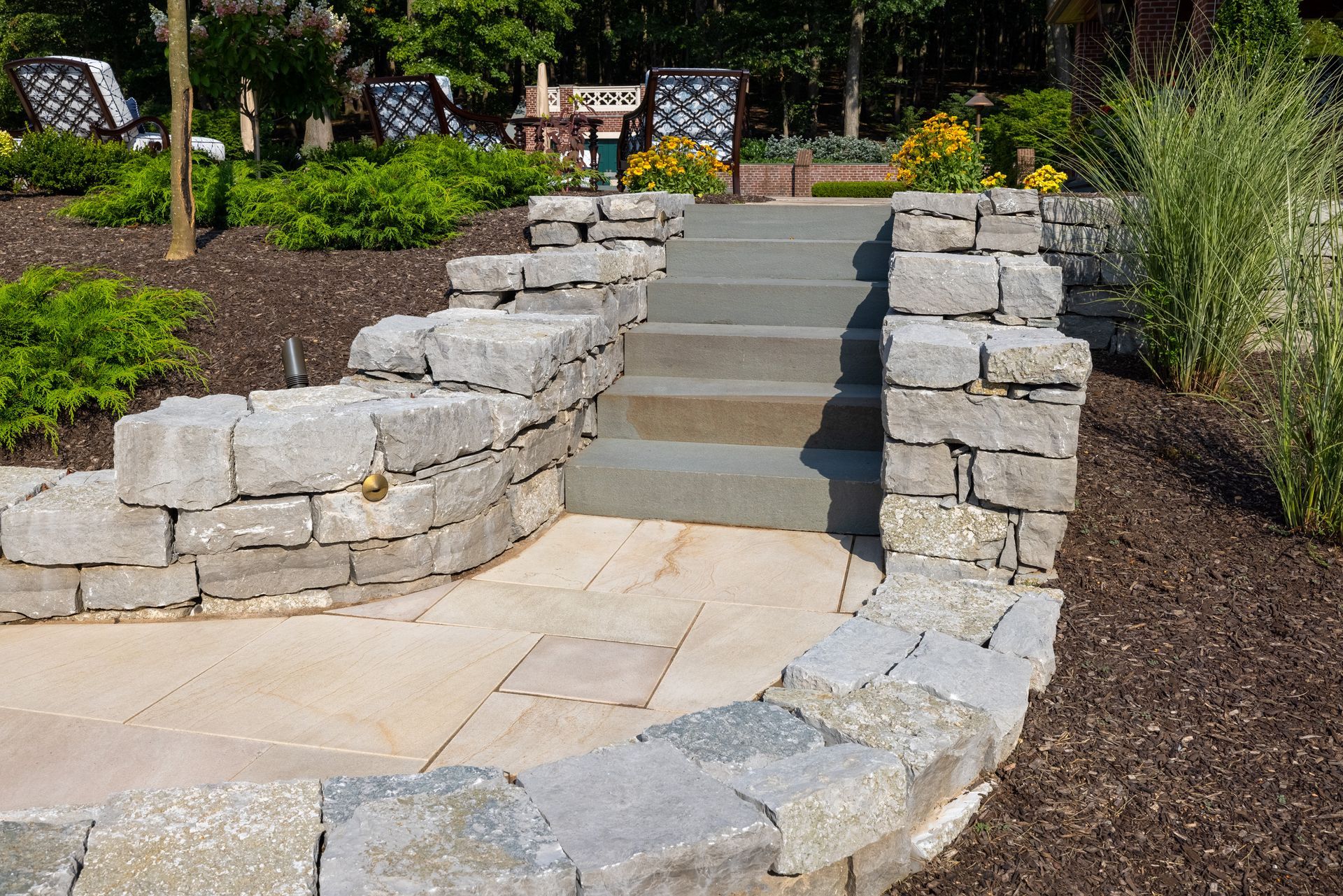A stone walkway with stairs leading up to a patio