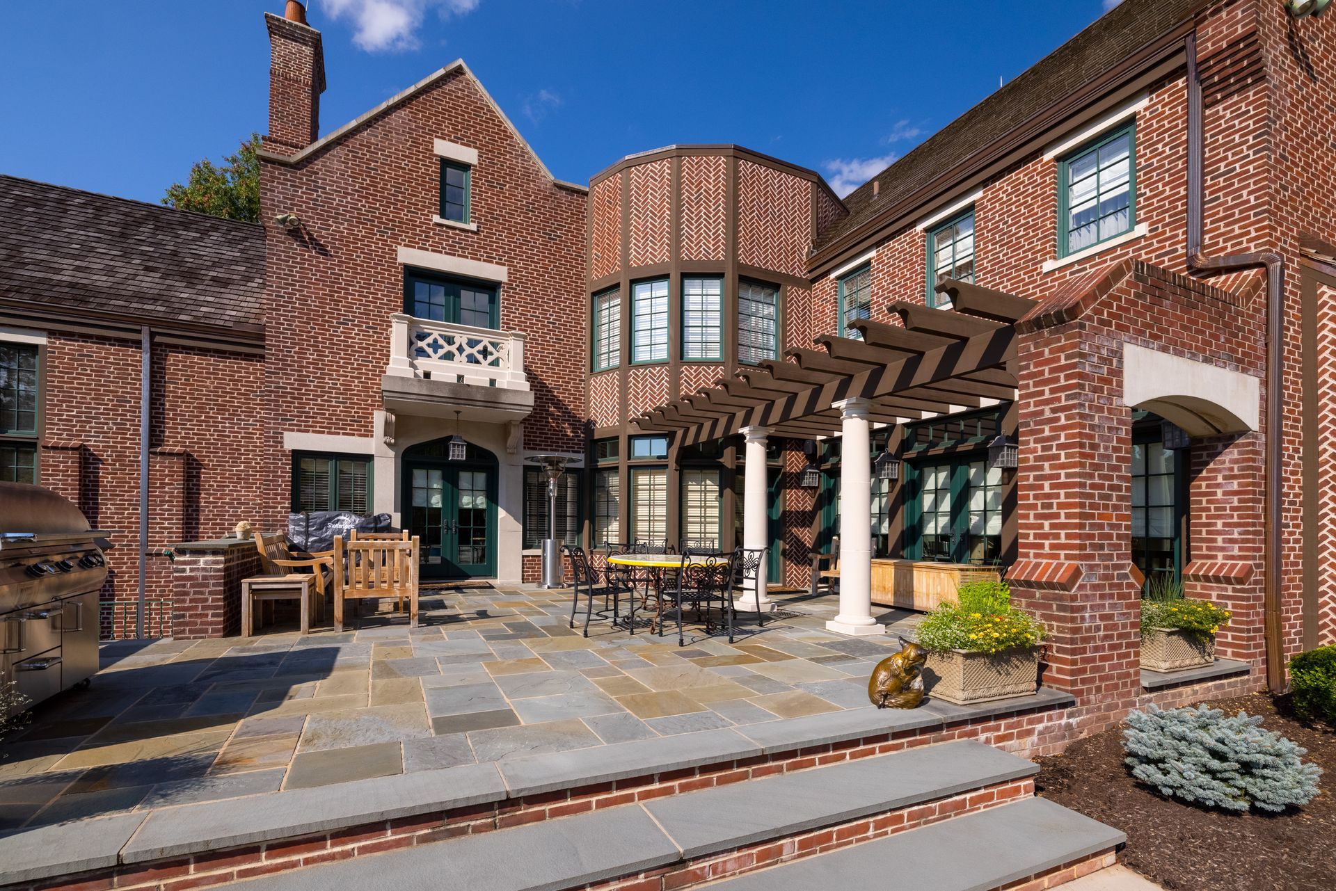 A large brick house with a patio in front of it.