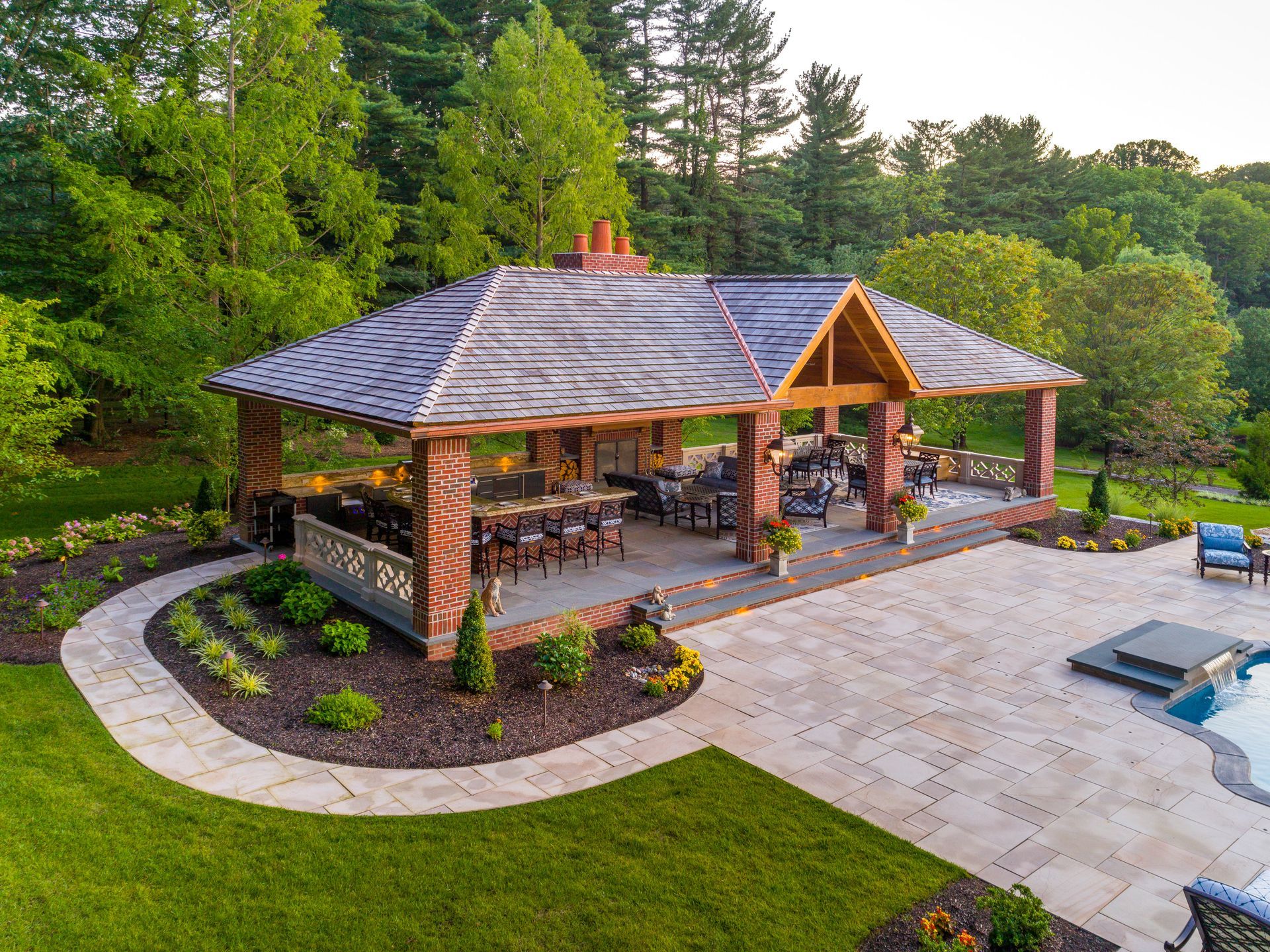 An aerial view of a large pavilion in the middle of a lush green backyard.