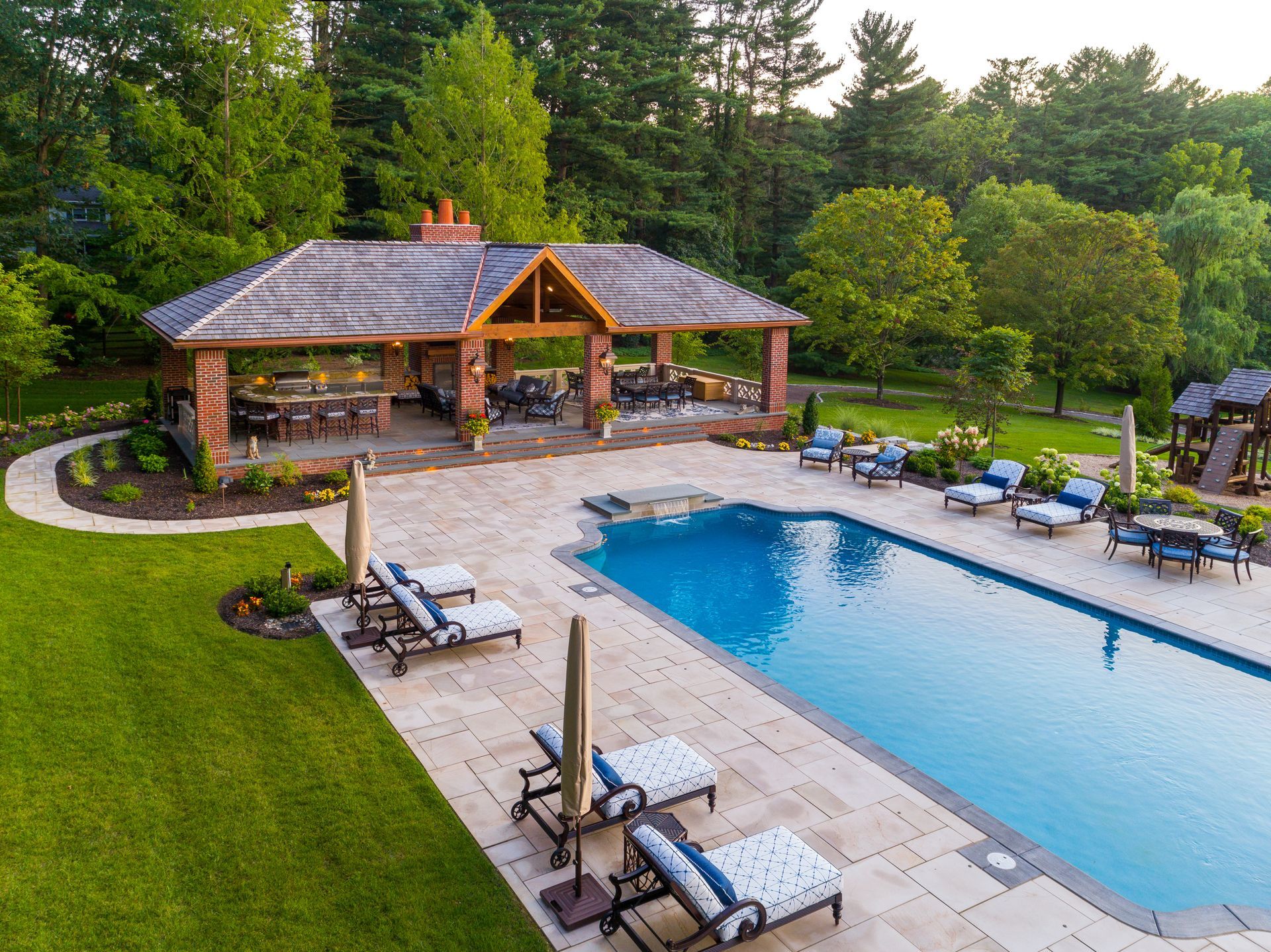 There is a large swimming pool in the backyard of a house.