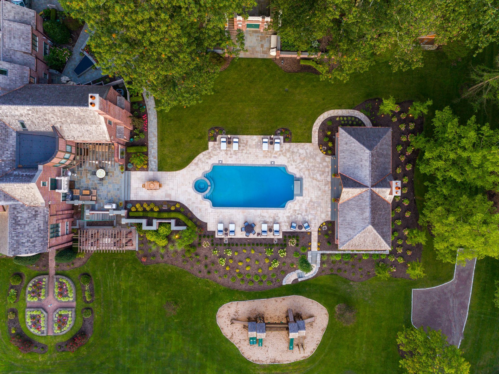 An aerial view of a large house with a large pool in the backyard.