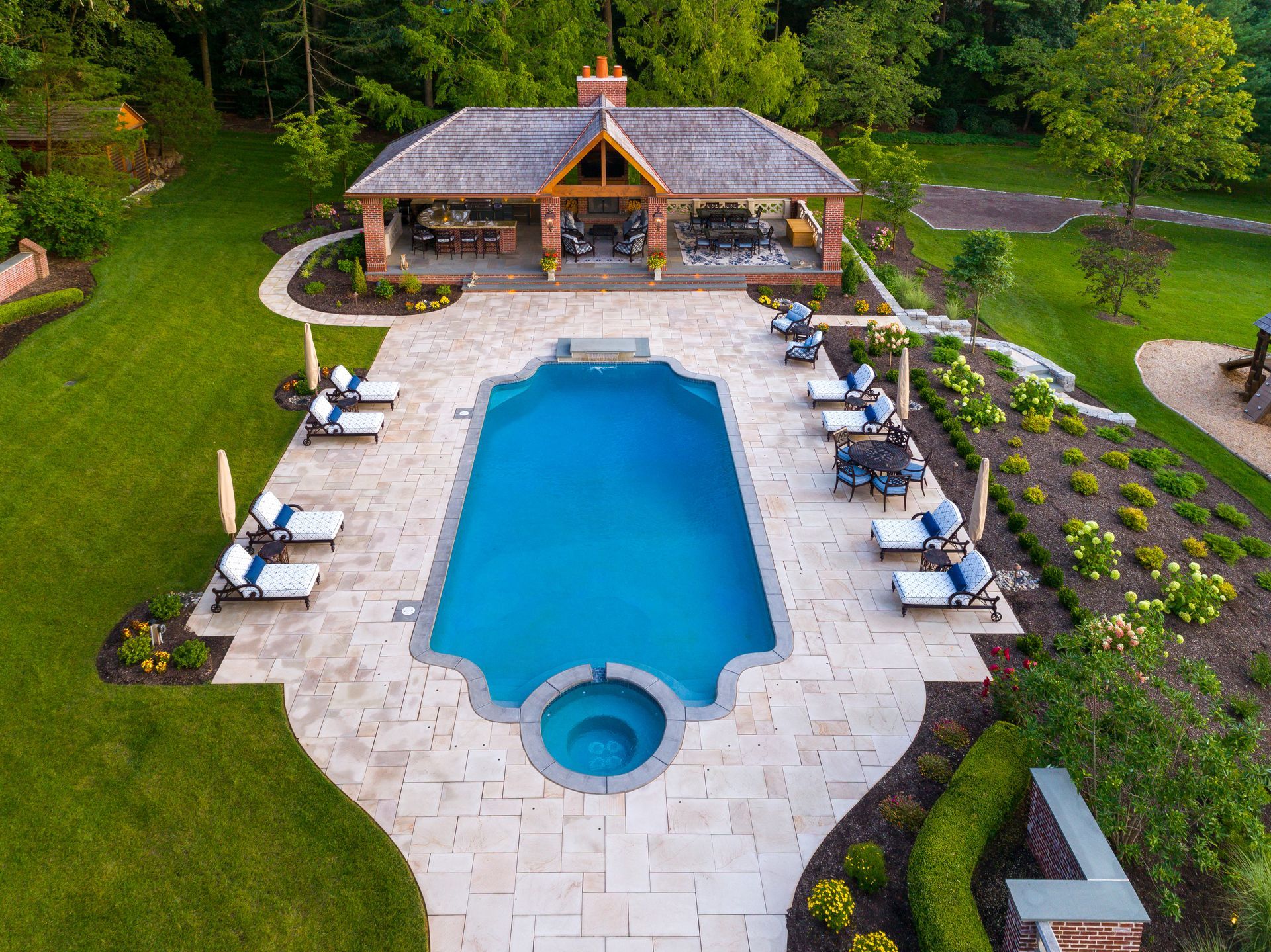 An aerial view of a large swimming pool with a gazebo in the background.