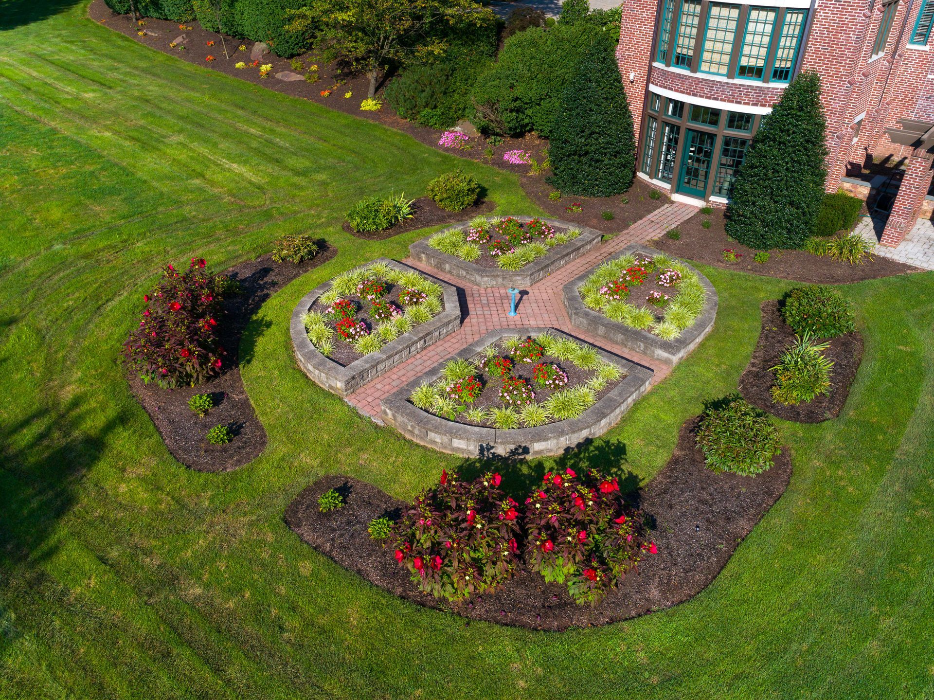 An aerial view of a circular garden in front of a brick house.