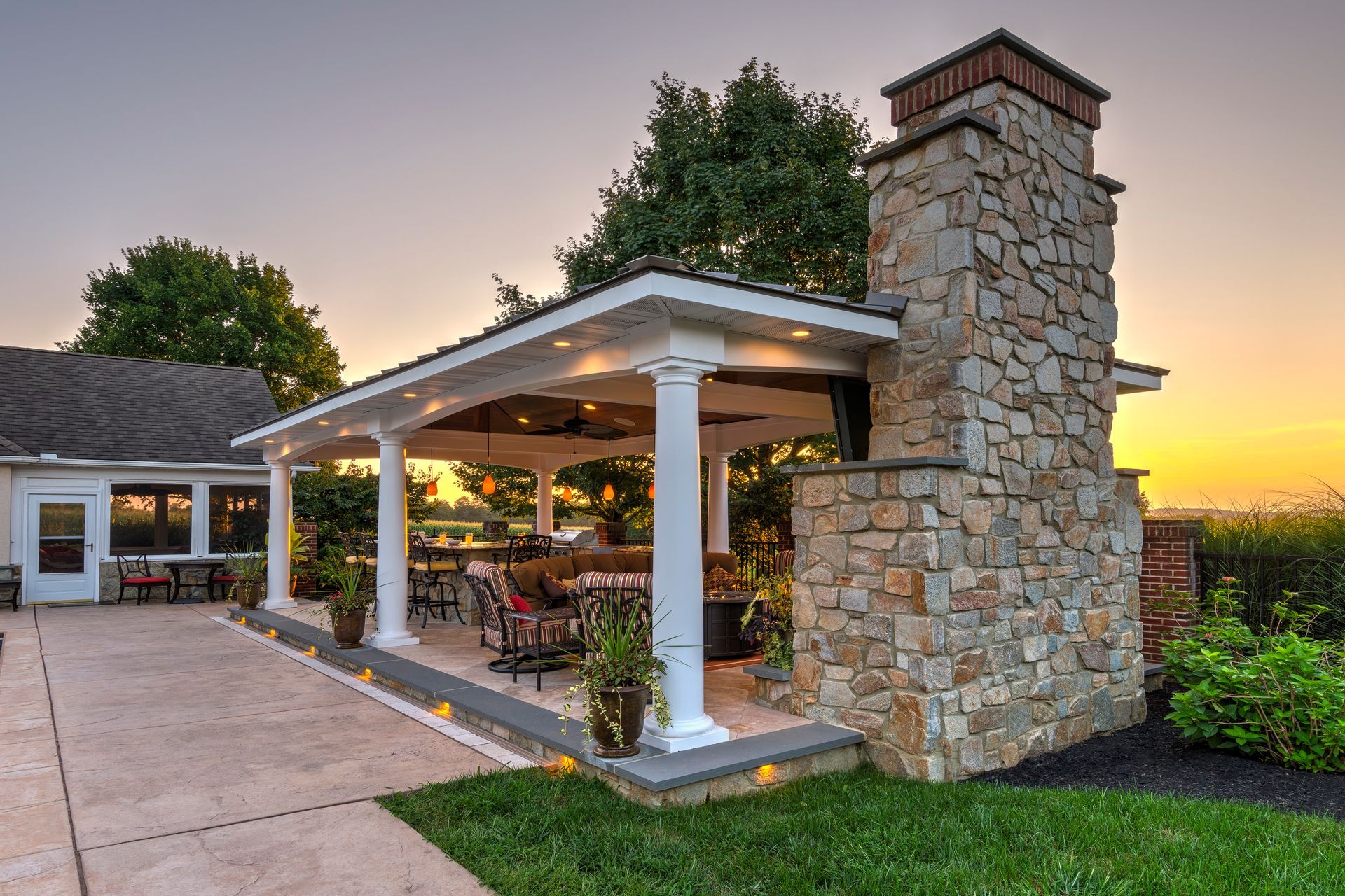 A patio with a stone fireplace and a covered area