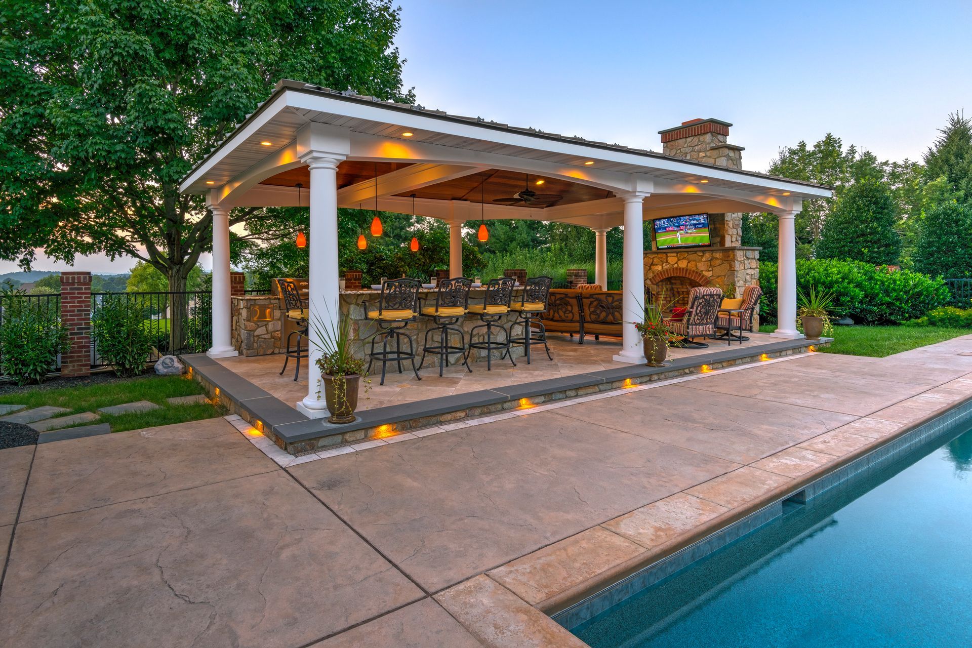 A large covered patio area next to a large swimming pool.