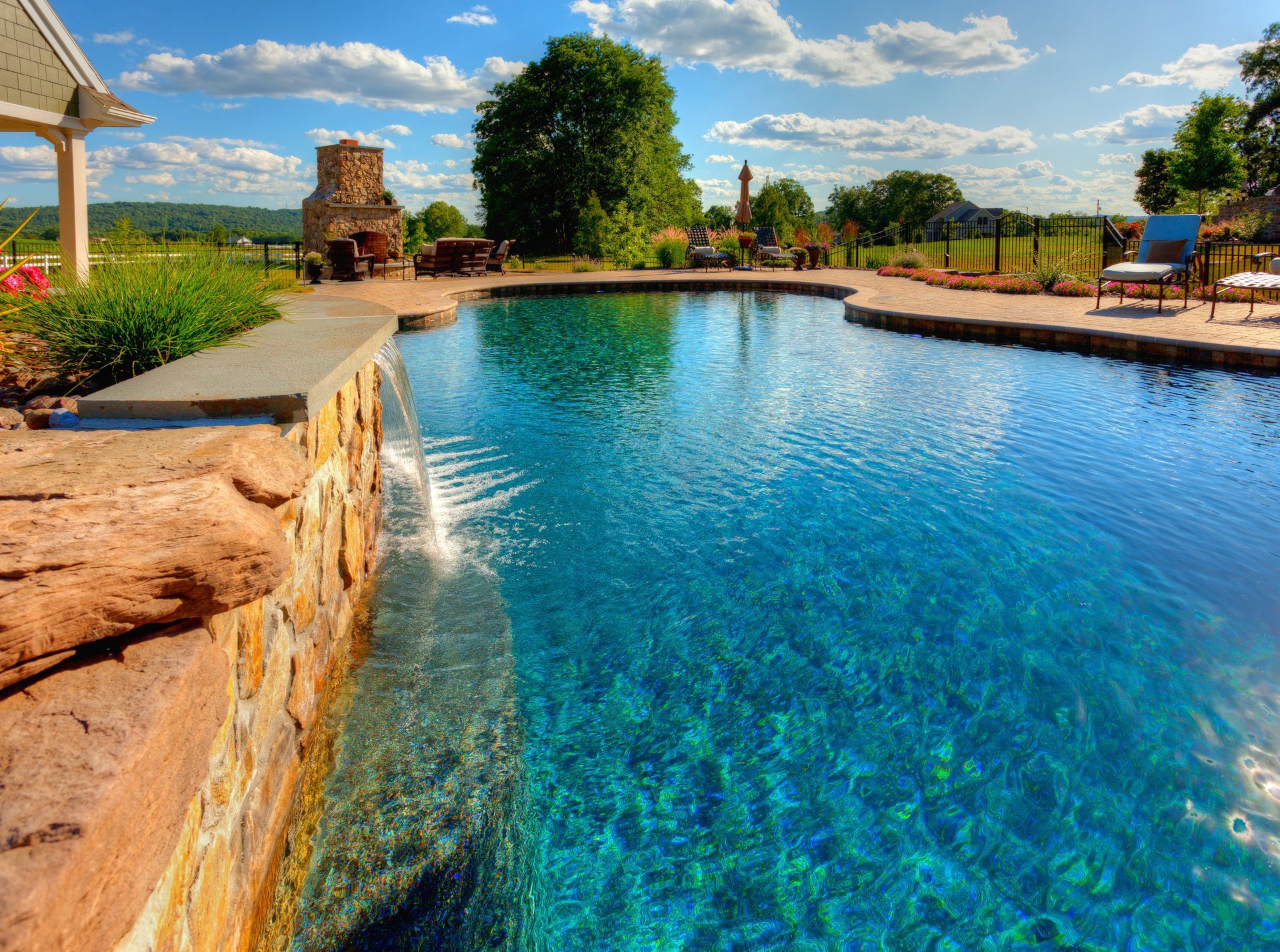 A large swimming pool with a waterfall in the middle