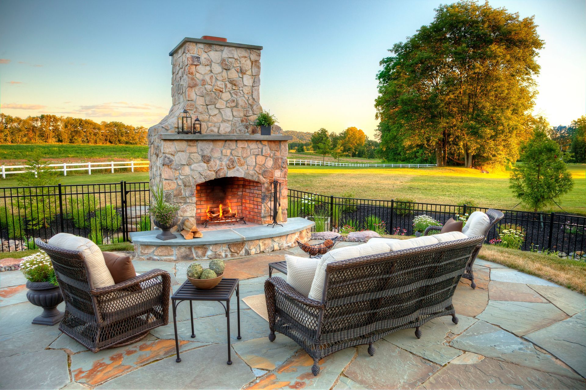 A patio with a fireplace and wicker furniture