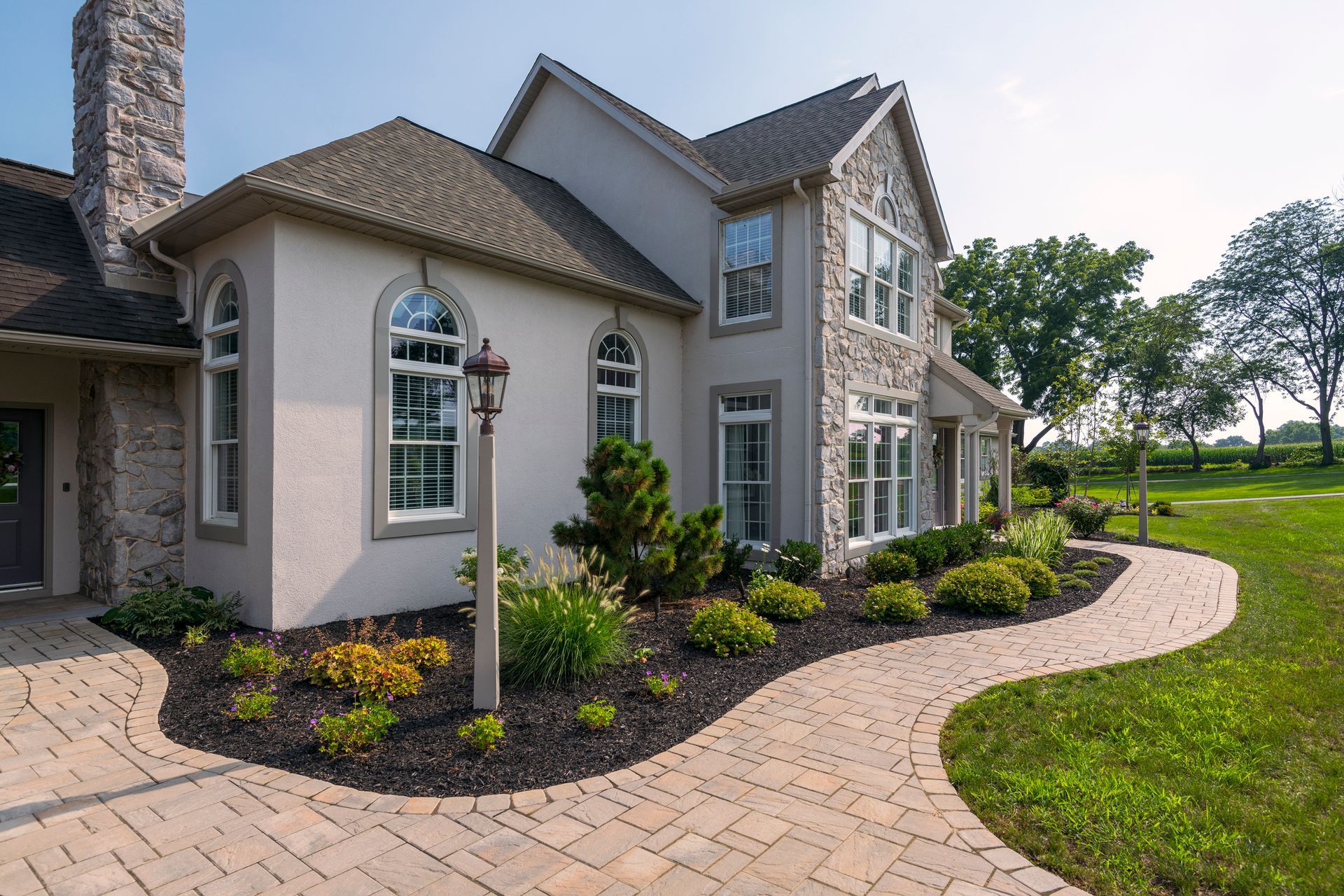 A large house with a brick walkway leading to it.