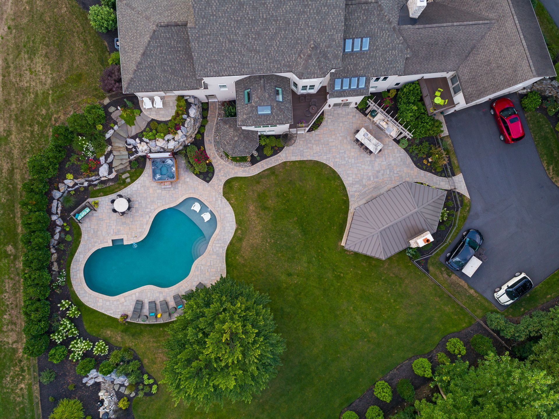 An aerial view of a large house with a swimming pool in the backyard.