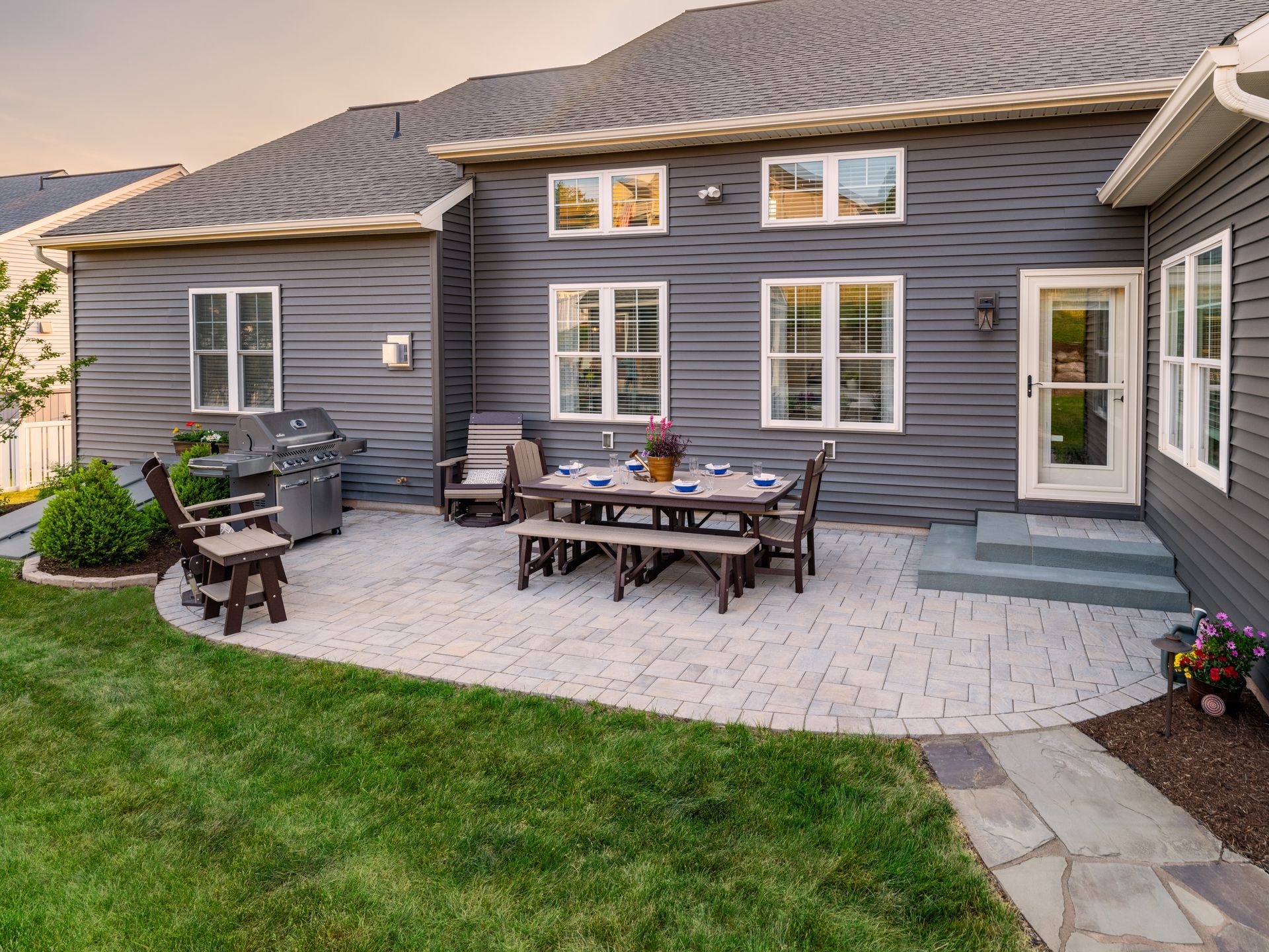 A patio with a table and chairs in front of a house.