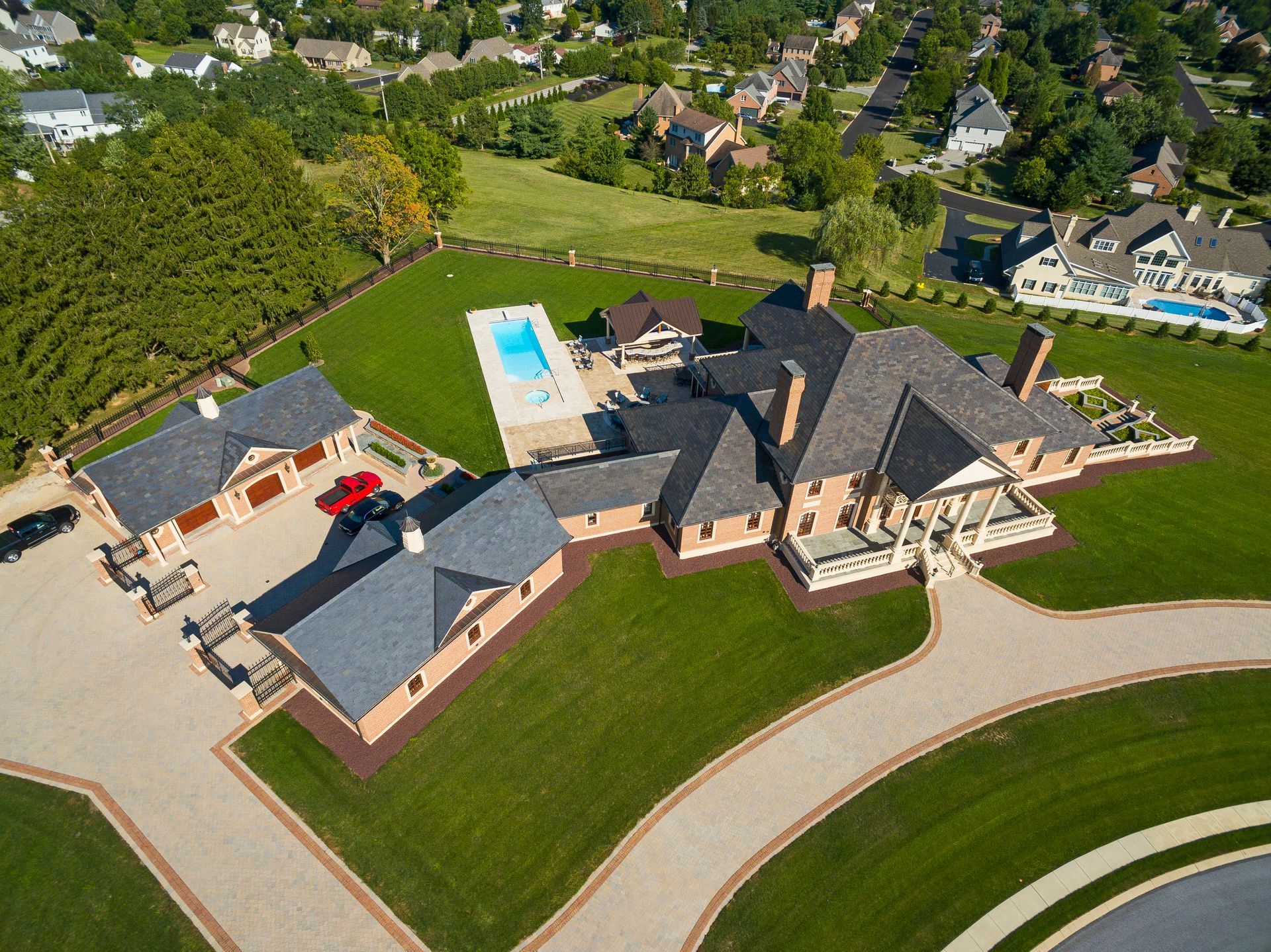 An aerial view of a large house with a pool in the backyard