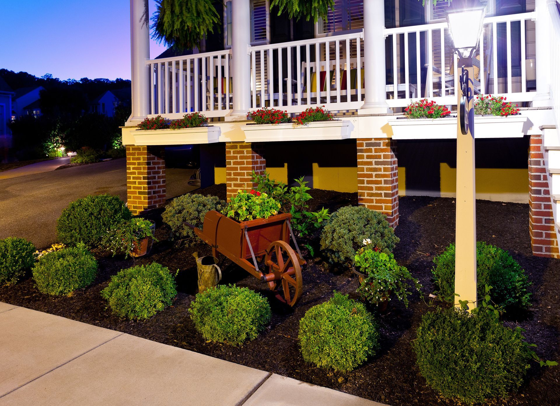 A wheelbarrow with plants in it sits in front of a house