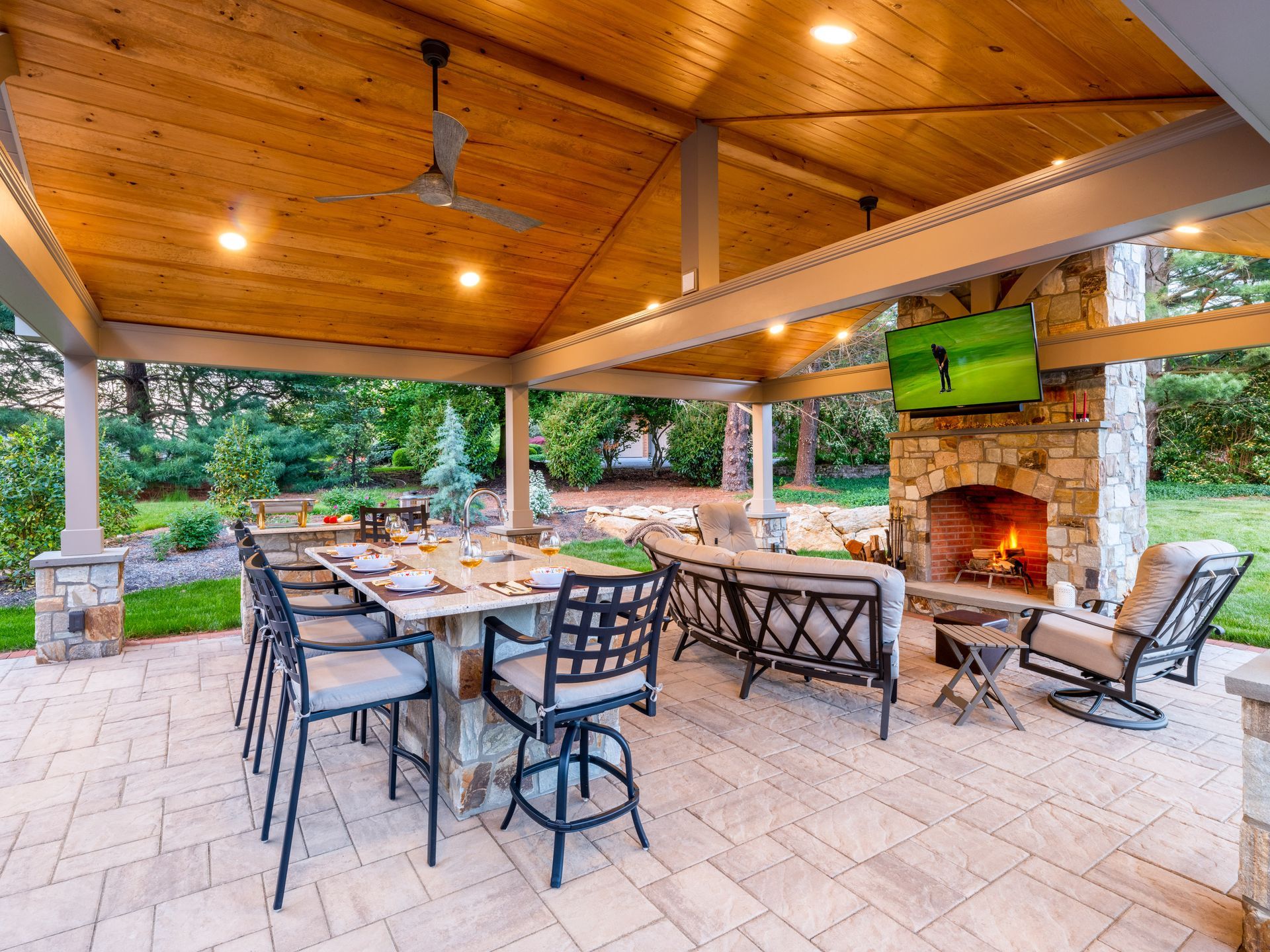 A patio with a table and chairs and a fireplace.