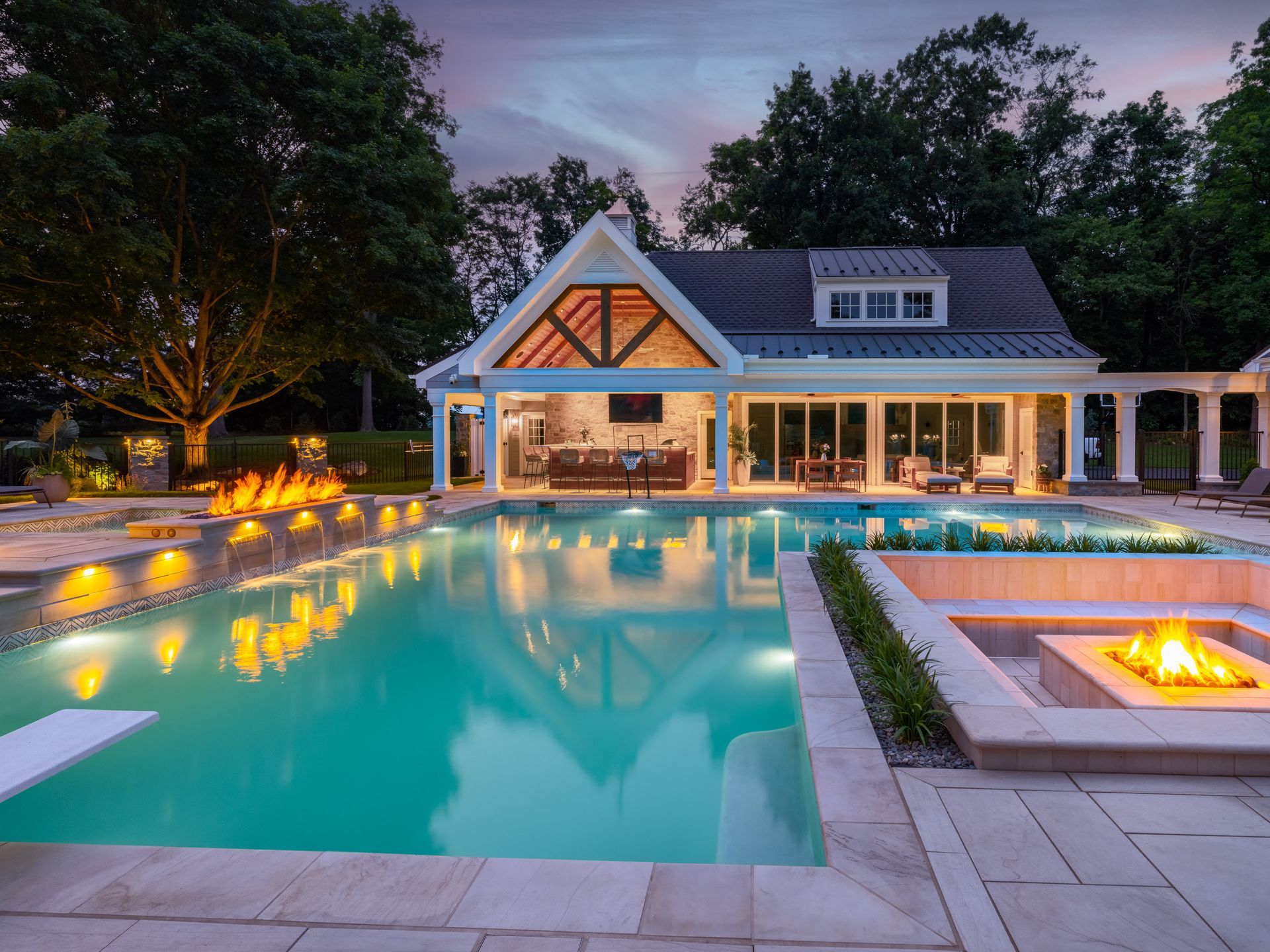 A large house with a swimming pool and a fire pit