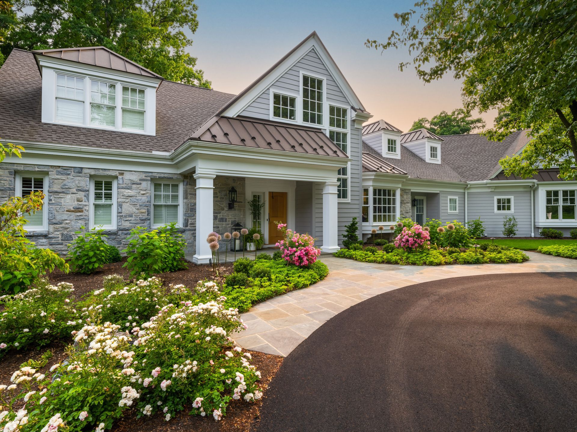 A large house with a lot of windows and flowers in front of it