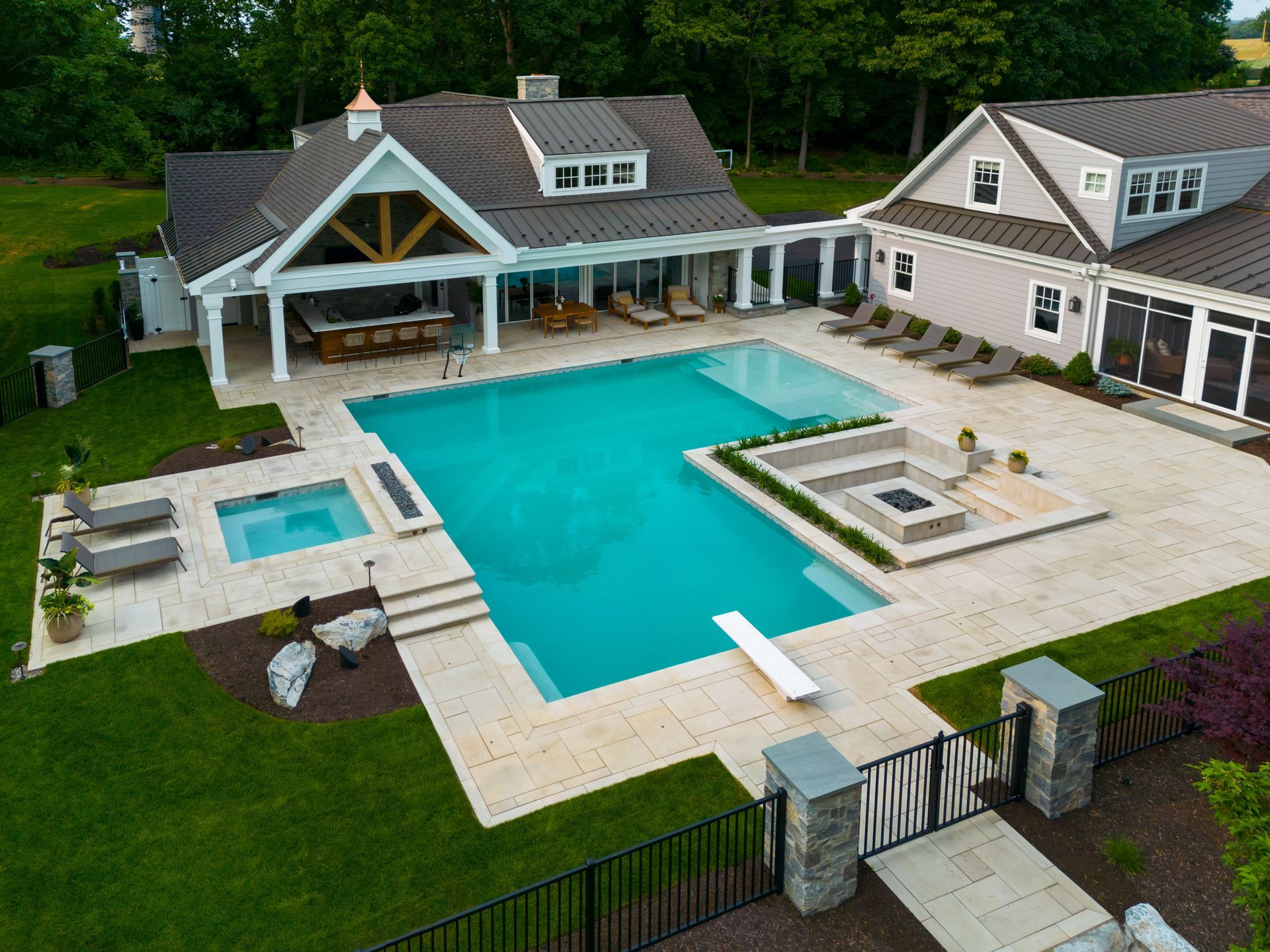 An aerial view of a large house with a large swimming pool in the backyard.