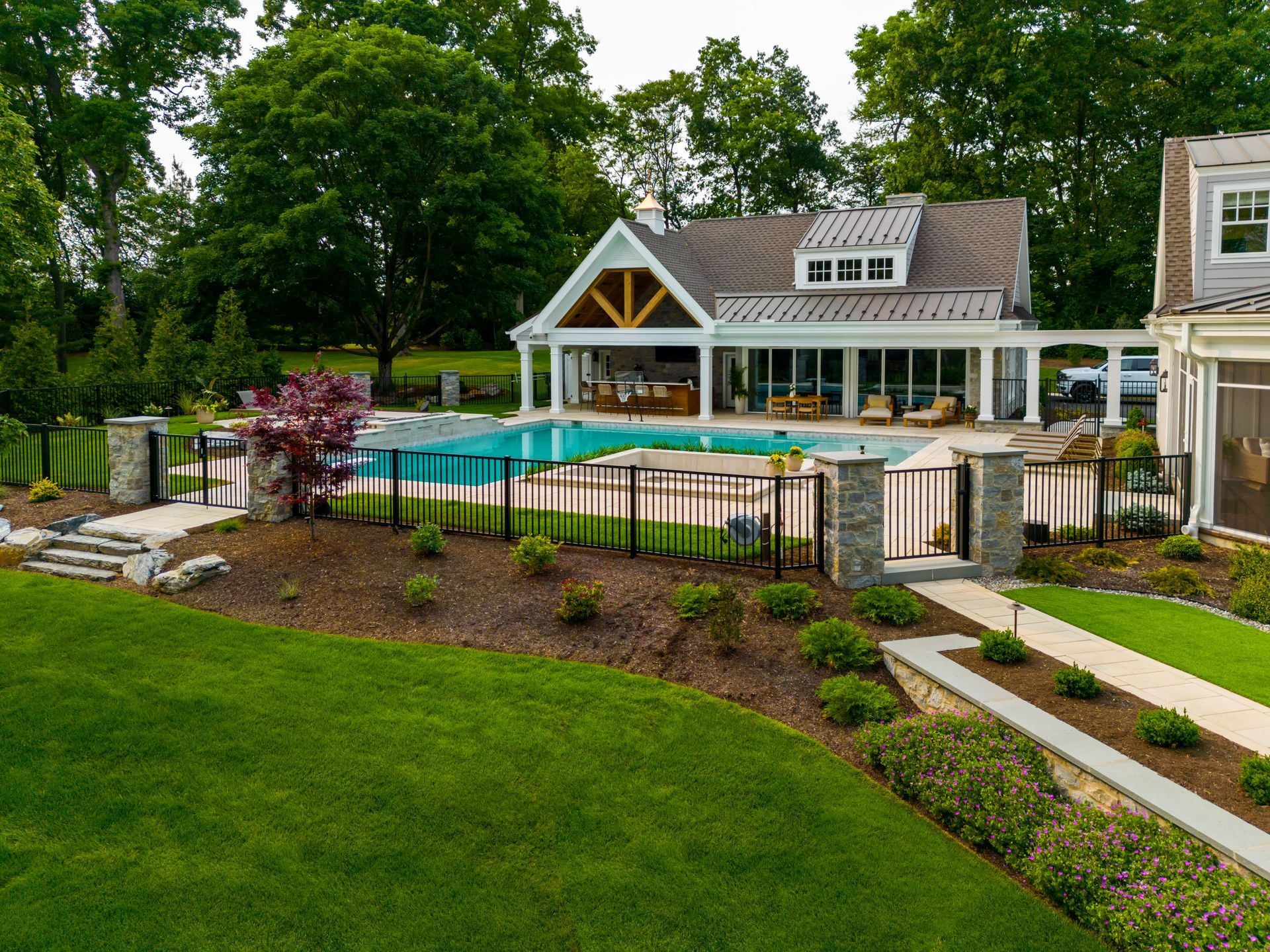 An aerial view of a large house with a swimming pool in the backyard.
