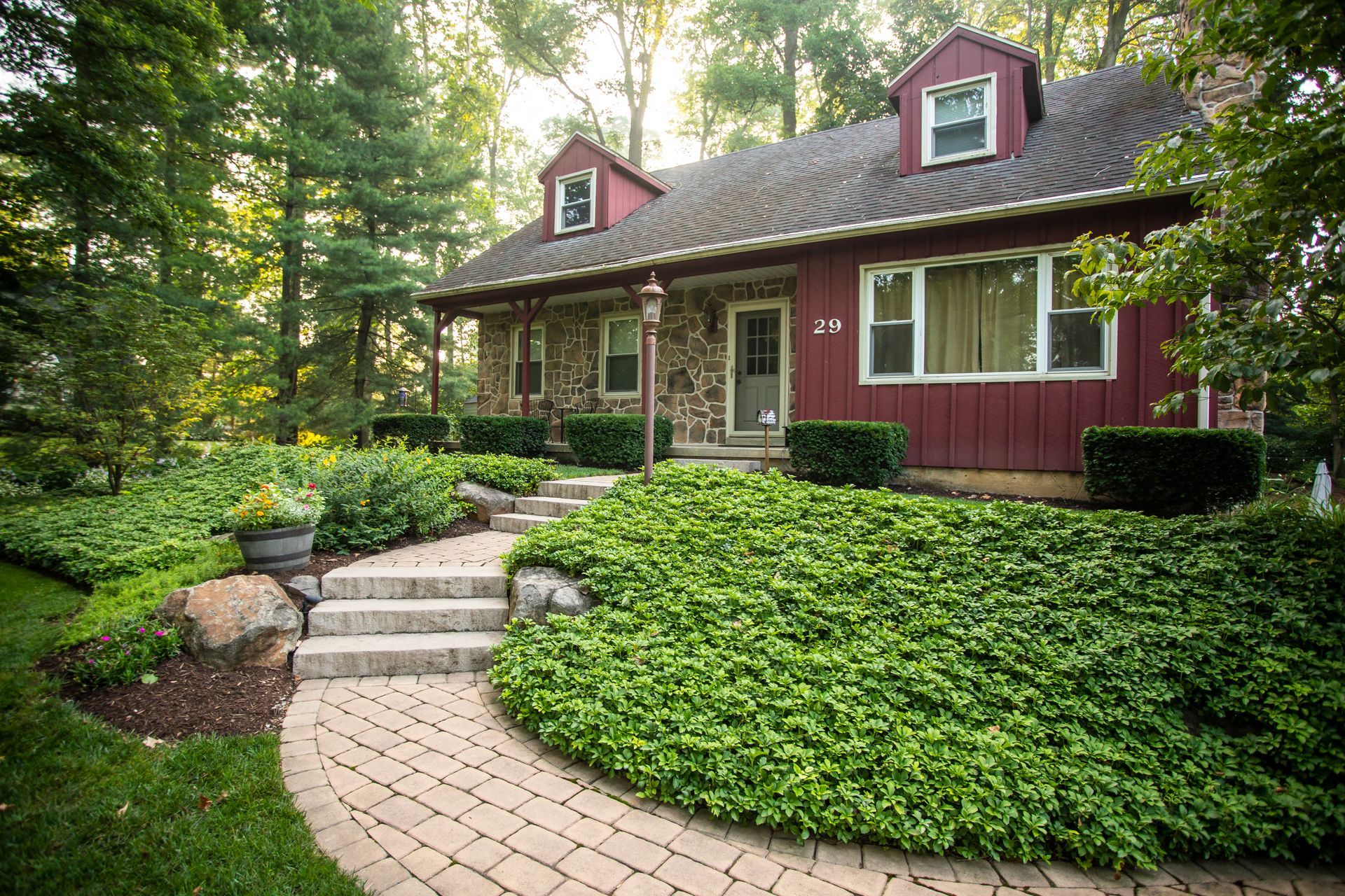 A red house with a brick walkway leading to it
