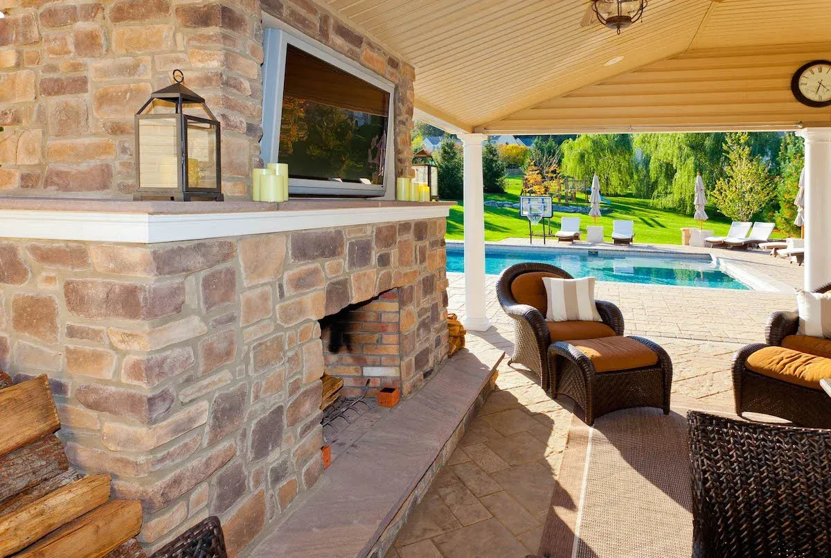 A patio with a fireplace and a flat screen tv.