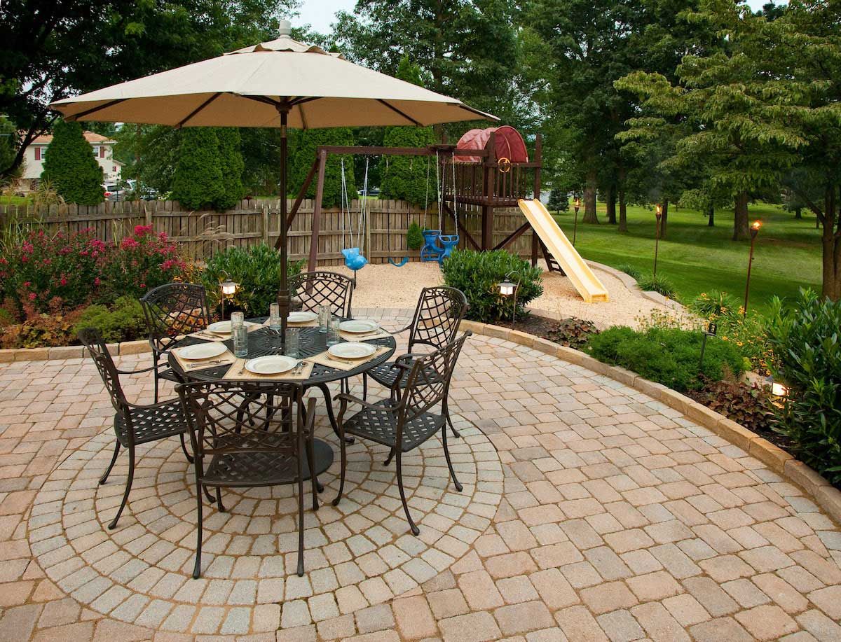 A patio with a table and chairs under an umbrella