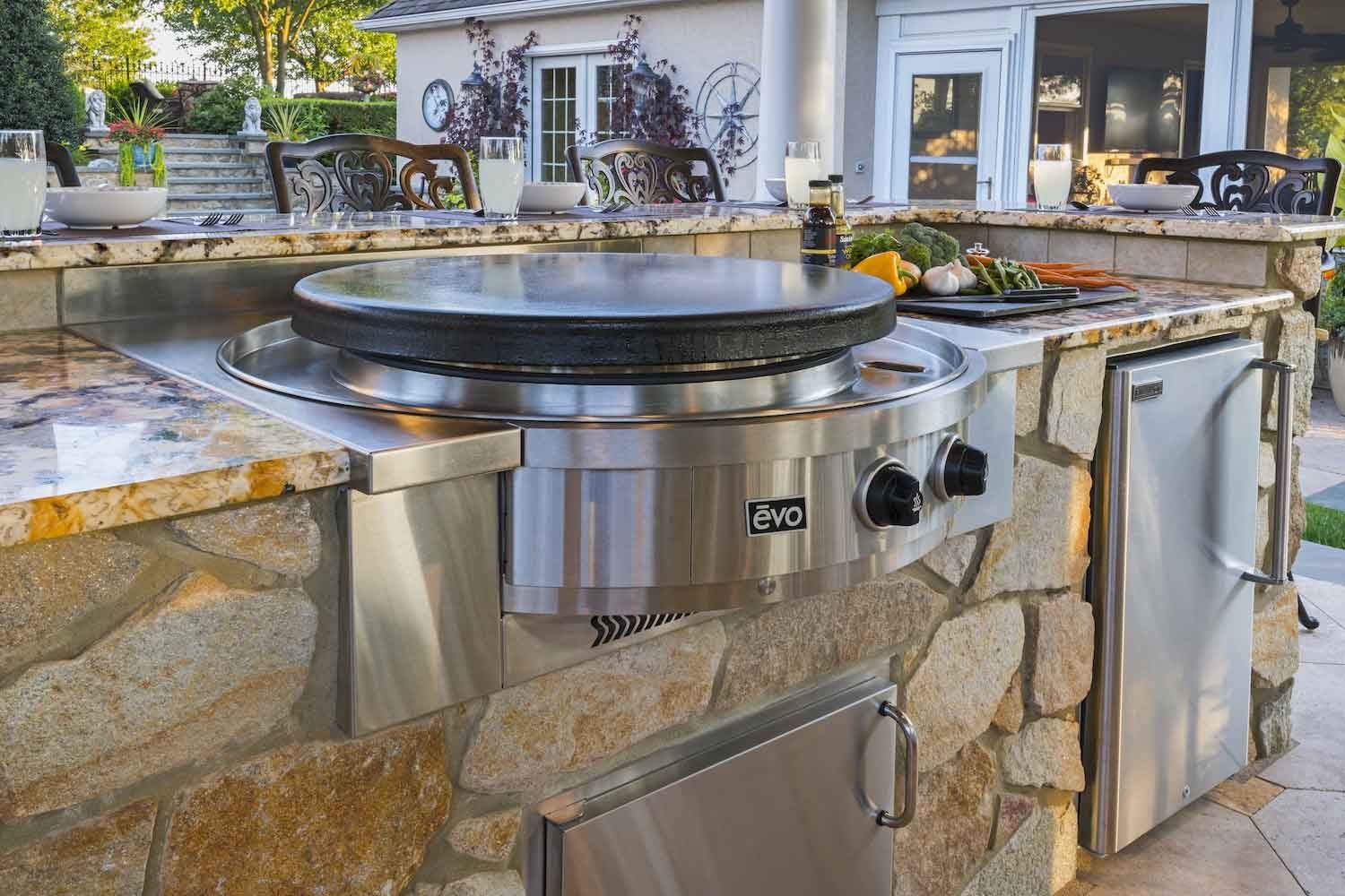 A stainless steel grill is sitting on top of a stone counter.