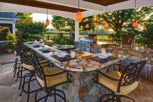 A patio with a table and chairs and a grill.