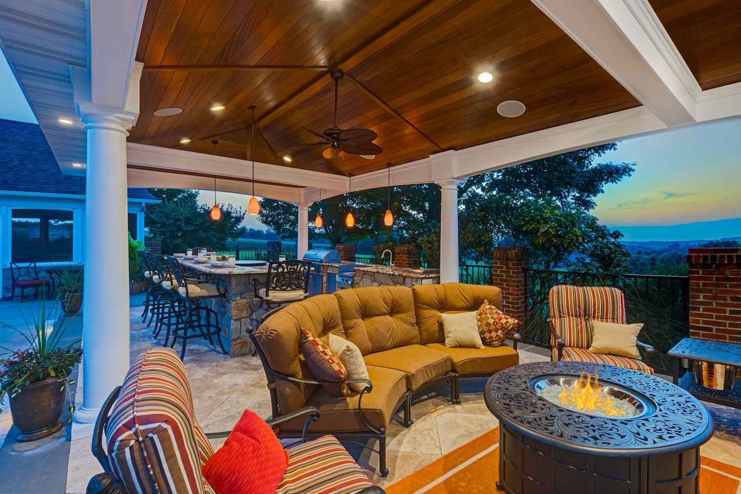 A patio with a table and chairs on it in front of a house.