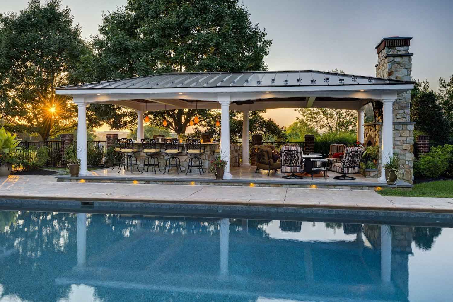 There is a large pool with a pavilion in the background.