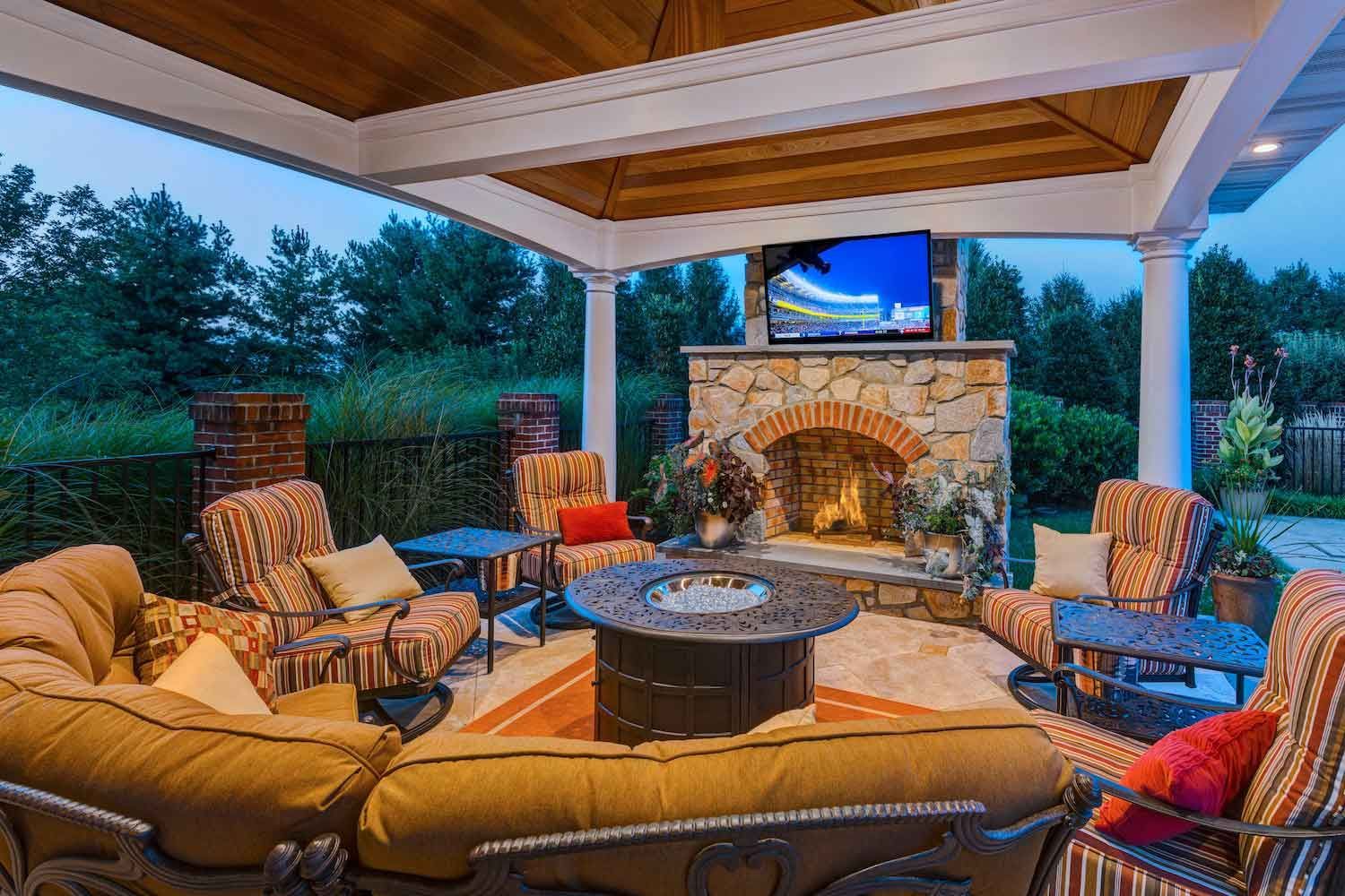 A patio with a table and chairs on it in front of a house.