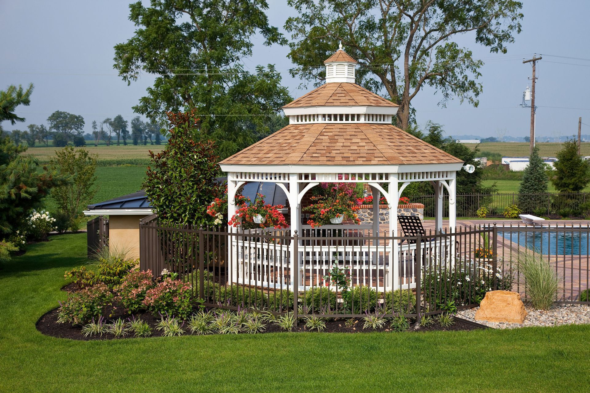 A gazebo in a backyard next to a pool