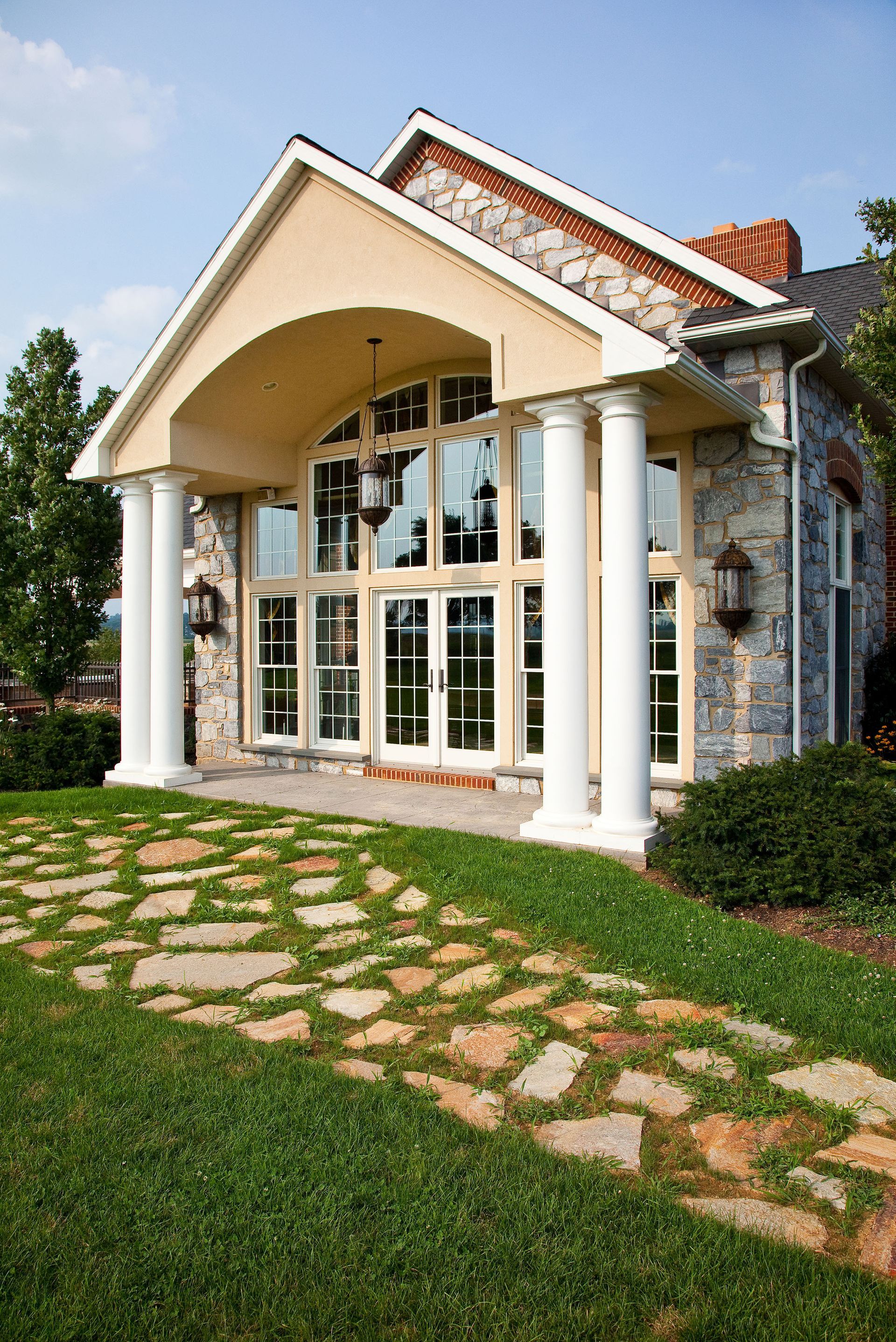 A large house with a stone walkway leading to it.
