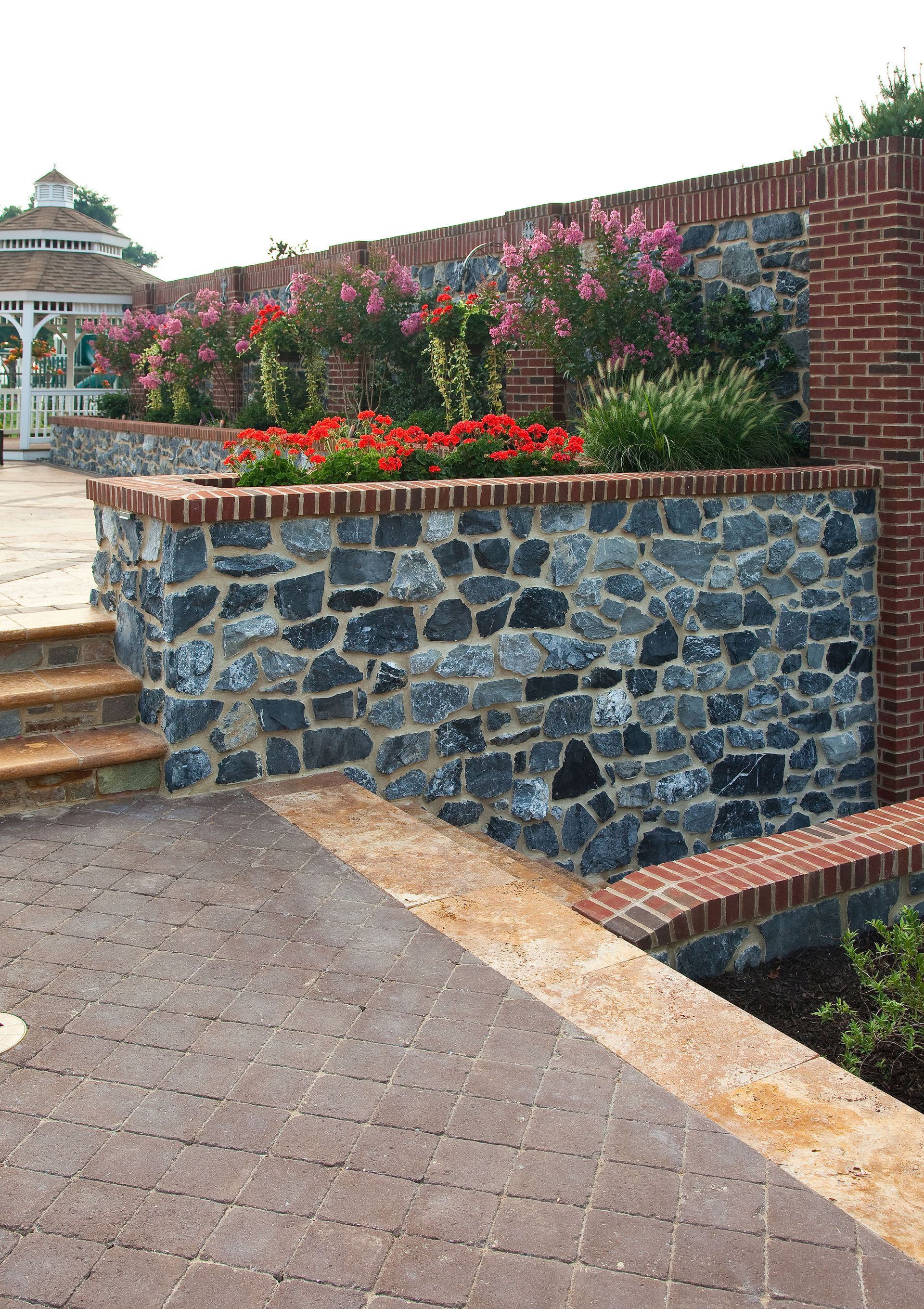 A stone wall with stairs and flowers on it