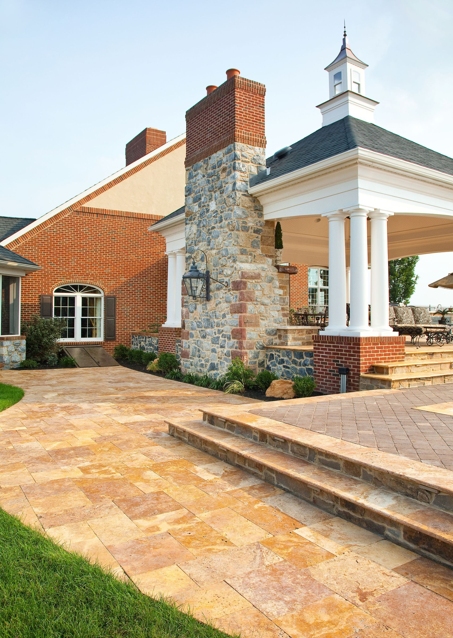 A large brick house with a gazebo in front of it.