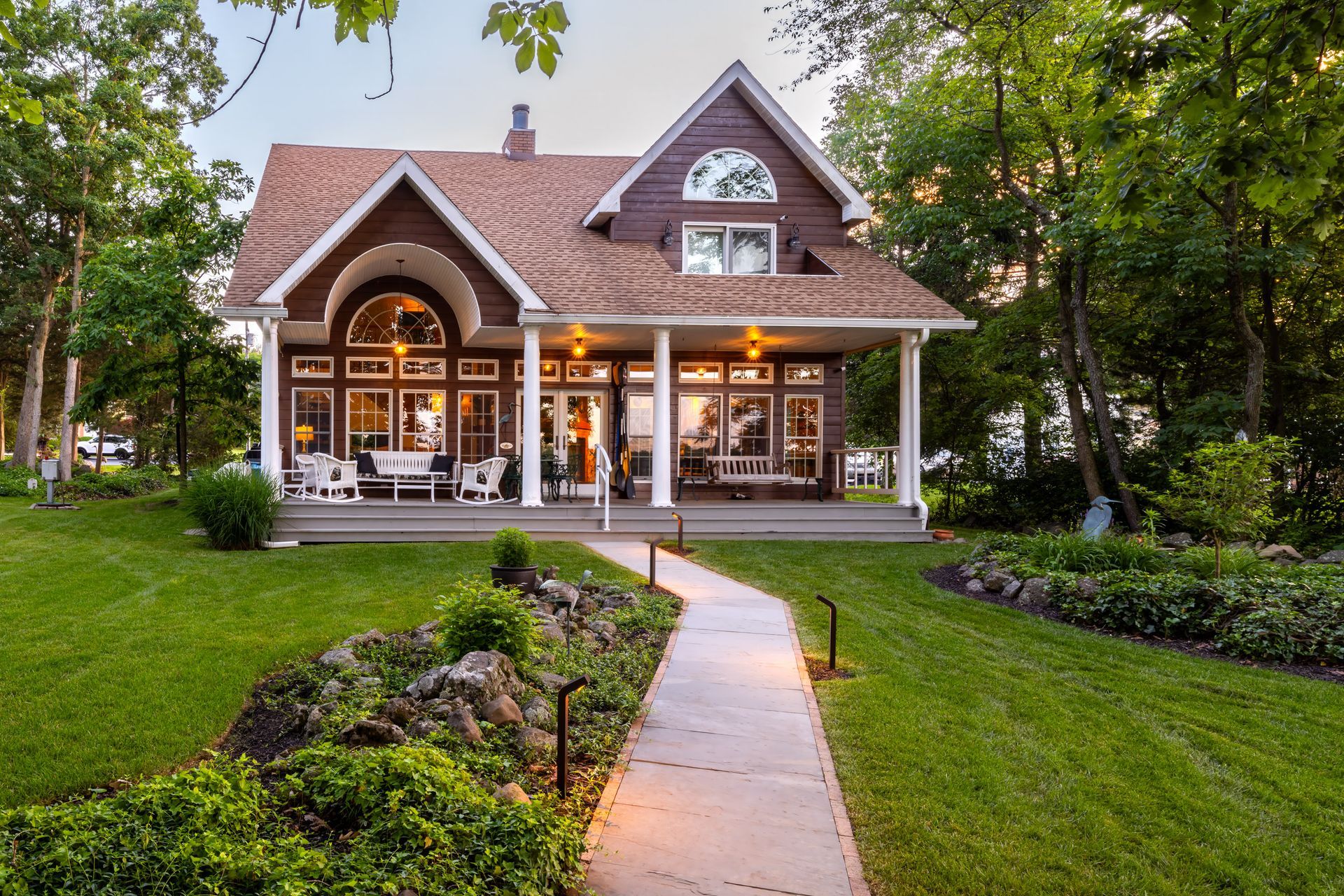 A large house with a large porch and a walkway leading to it.