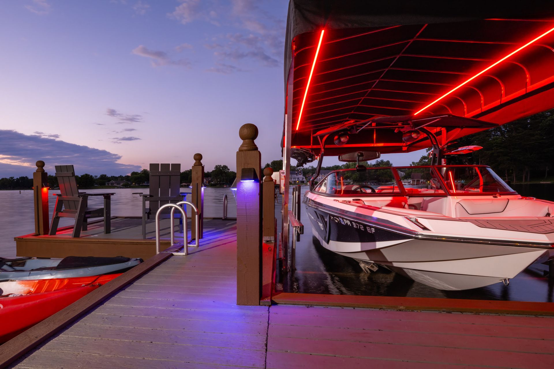 A boat is docked at a dock with red and blue lights.
