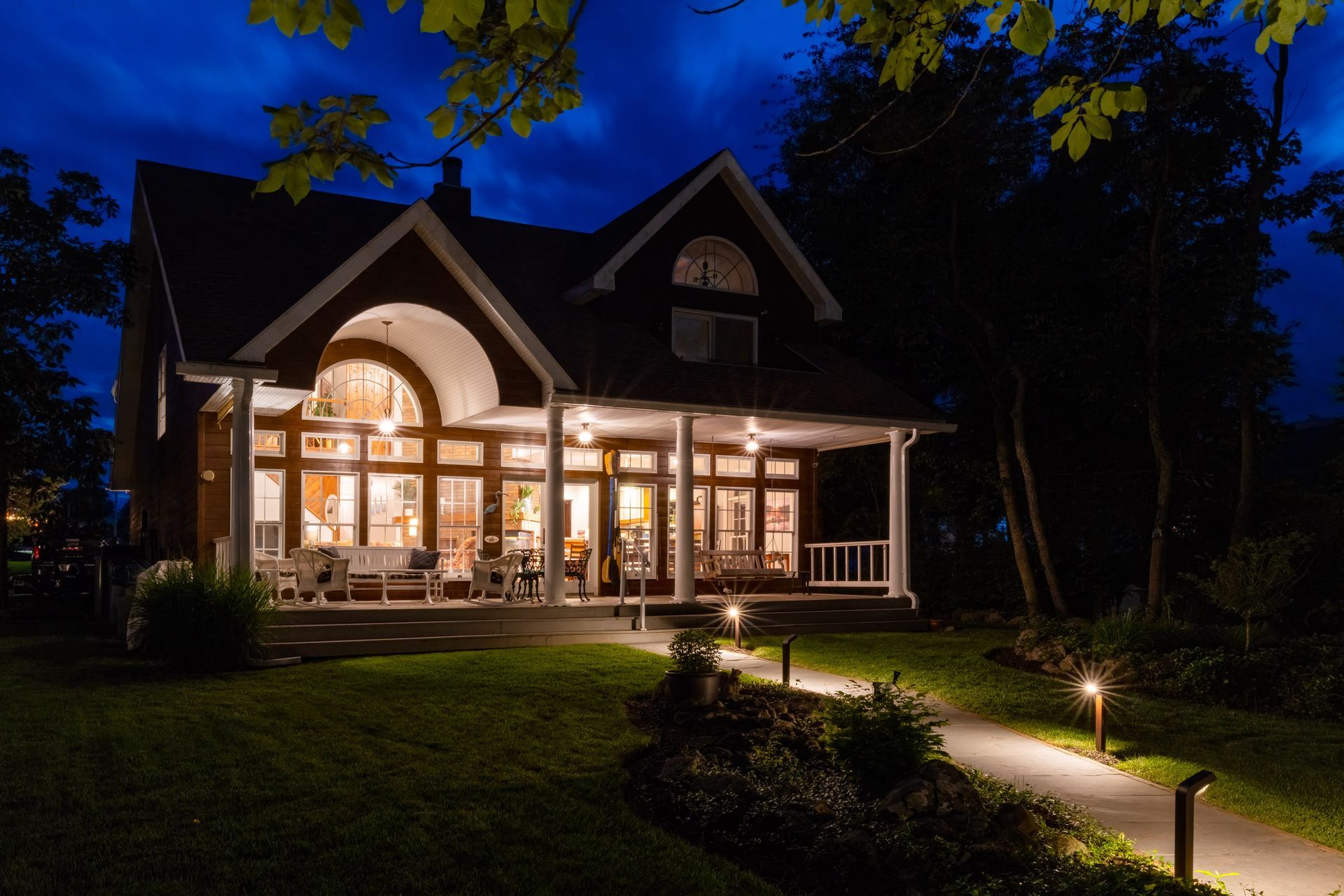 A house with a large porch is lit up at night