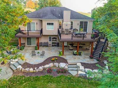 An aerial view of a large house with a large deck and patio.