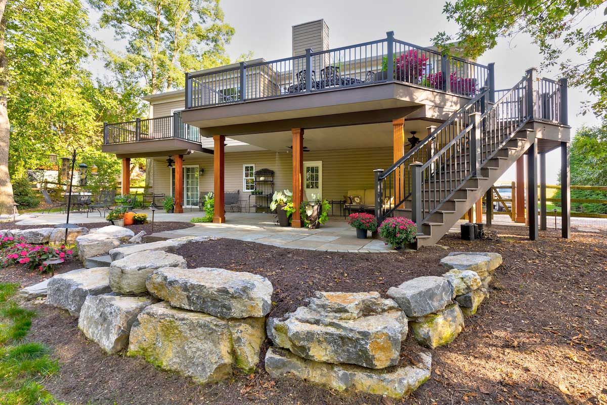 A large house with a large deck and stairs.