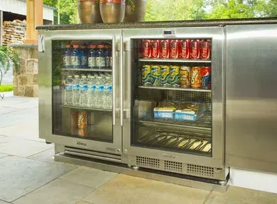 A stainless steel refrigerator filled with sodas and water bottles.