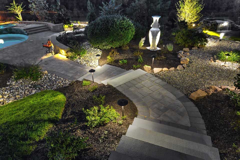 A walkway leading to a pool is lit up at night